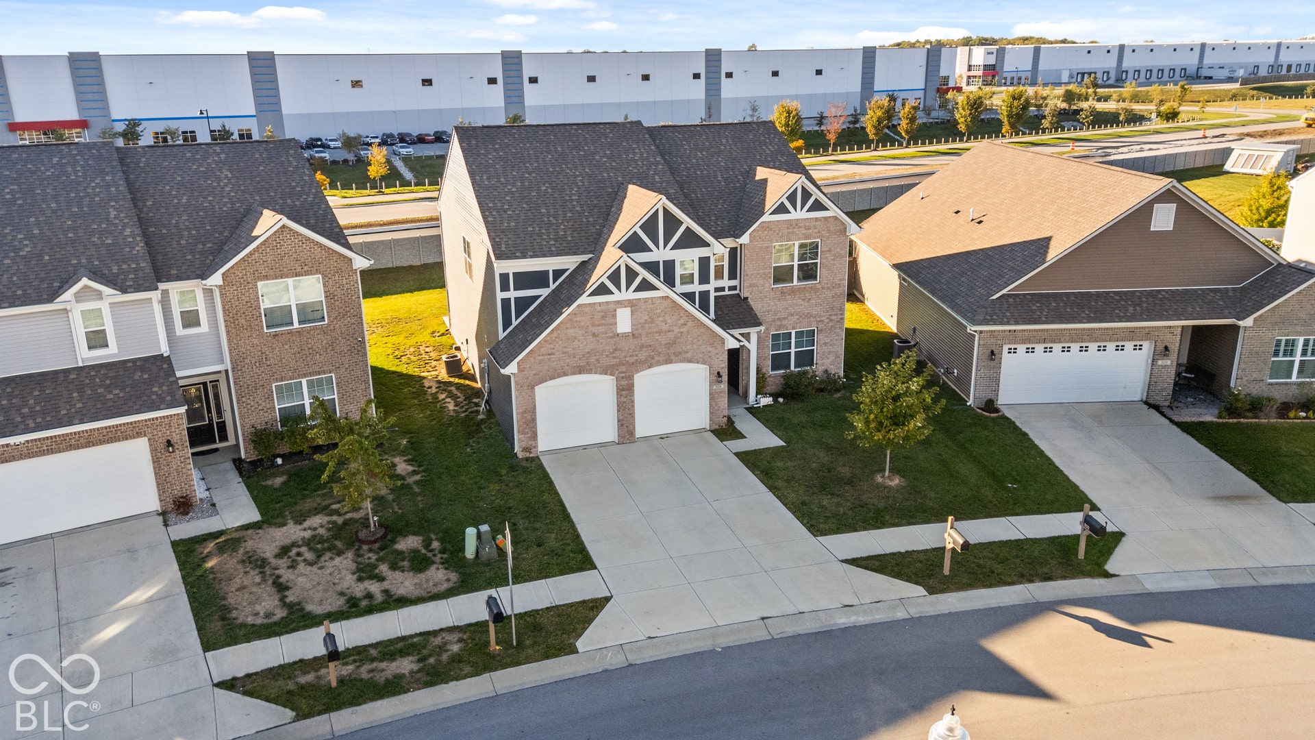 Two-story residence with a brick and siding exterior, dual garage doors, and a concrete driveway