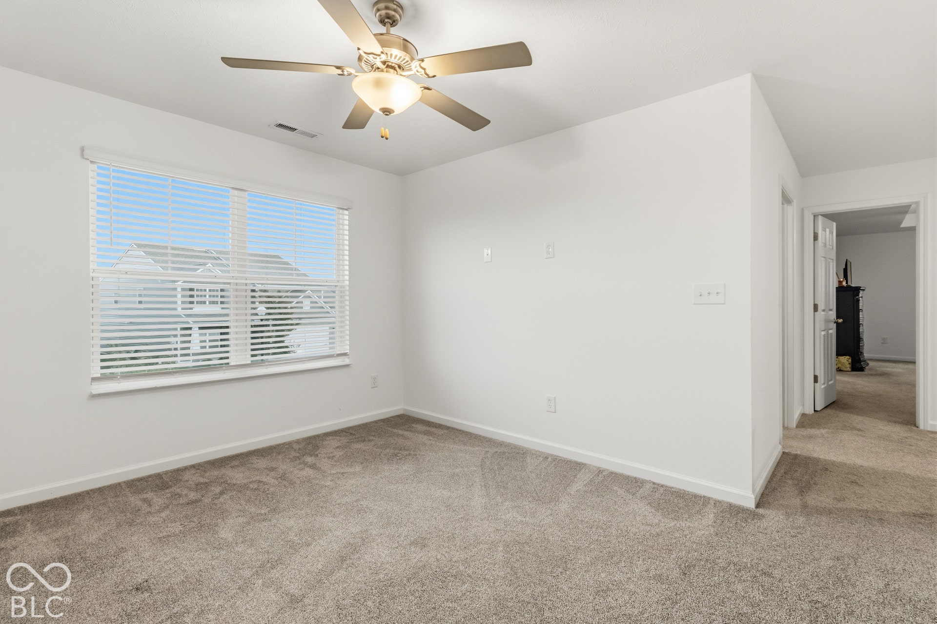 Window with white blinds, neutral wall paint, ceiling fan with light fixture, gray carpet flooring, and white trim