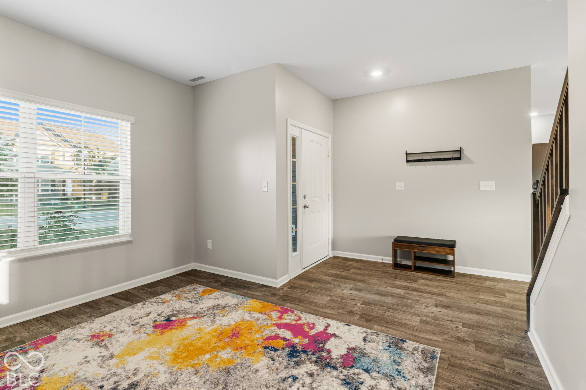 Wood-finish flooring, white trim, recessed lighting, and a white paneled door with glass inserts