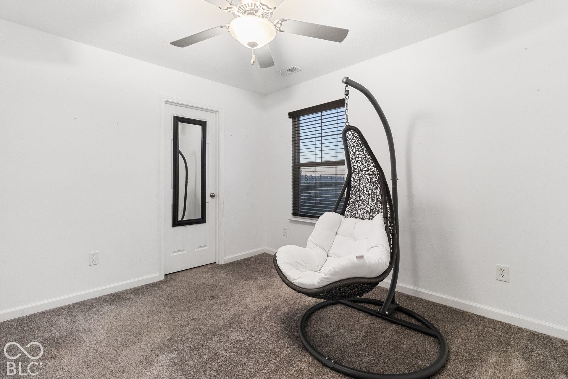Carpeted flooring, white walls, and a ceiling fan with integrated lighting