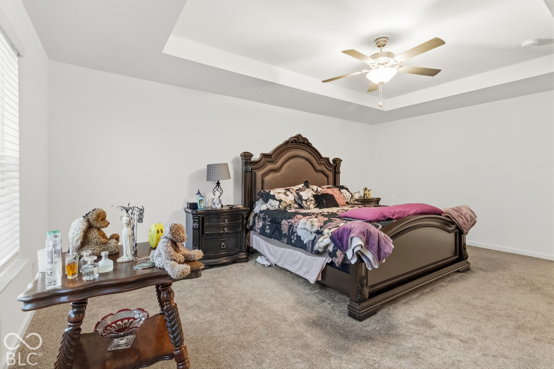Recessed ceiling with an integrated ceiling fan, carpeted flooring, and window with blinds