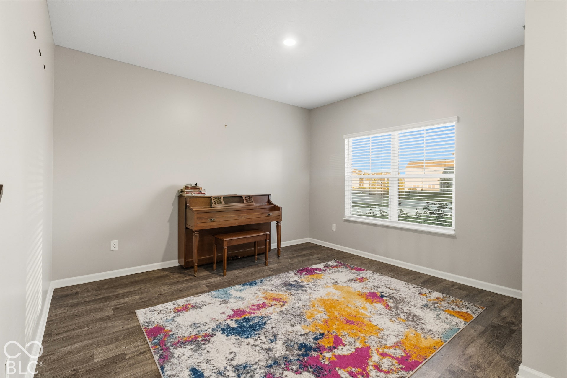 Recessed lighting, light gray wall paint, wood-finish flooring, and a window with horizontal blinds