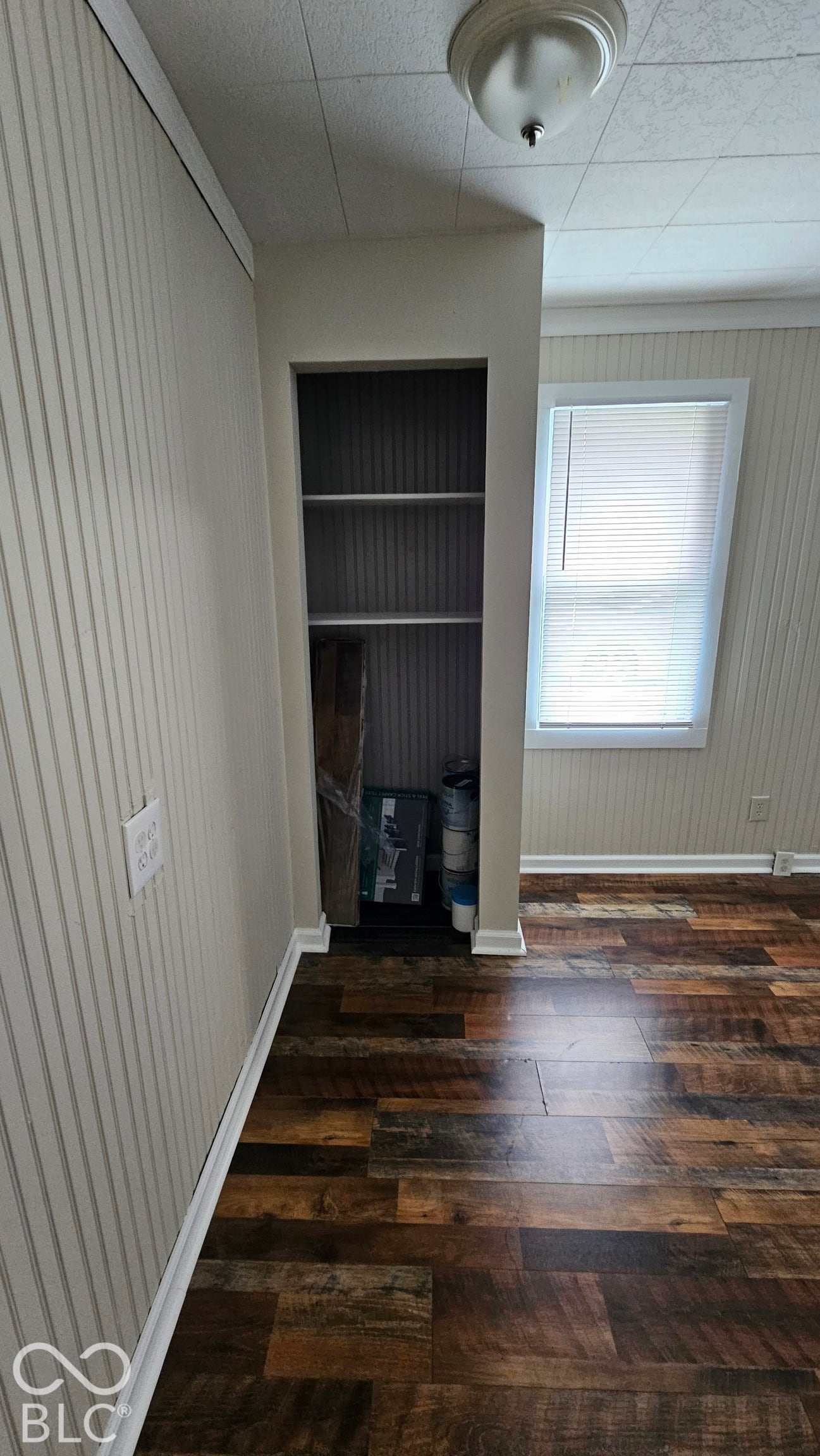 104 E State Street, New Ross, IN 47968 Wood-finish flooring, built-in shelving, window with blinds, beadboard wall paneling, and ceiling-mounted light fixture