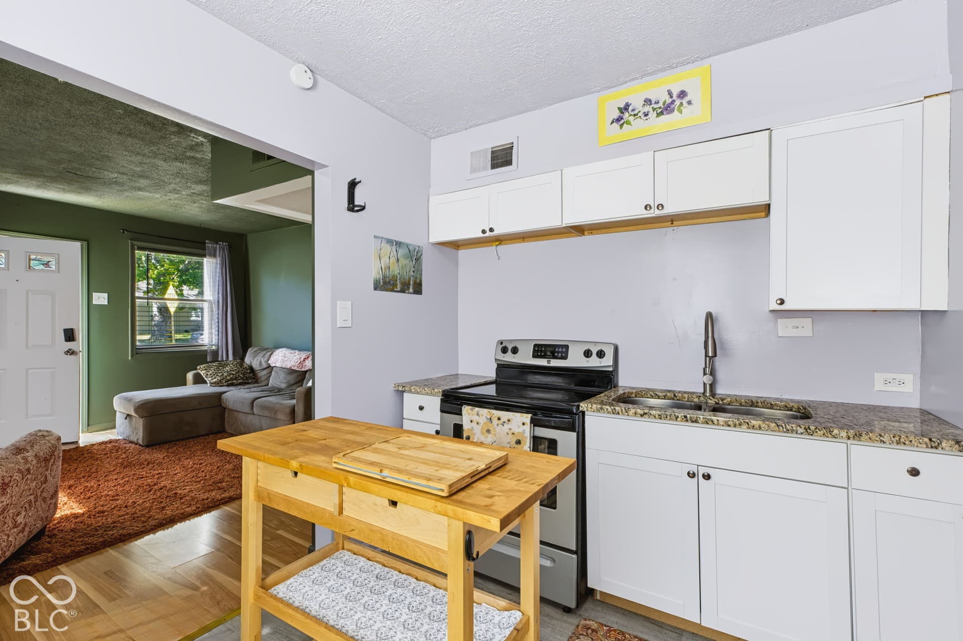2101 Sharon Avenue, Indianapolis, IN 46222 Kitchen featuring white cabinetry, granite-finish countertops, stainless steel sink, and a black and stainless steel range