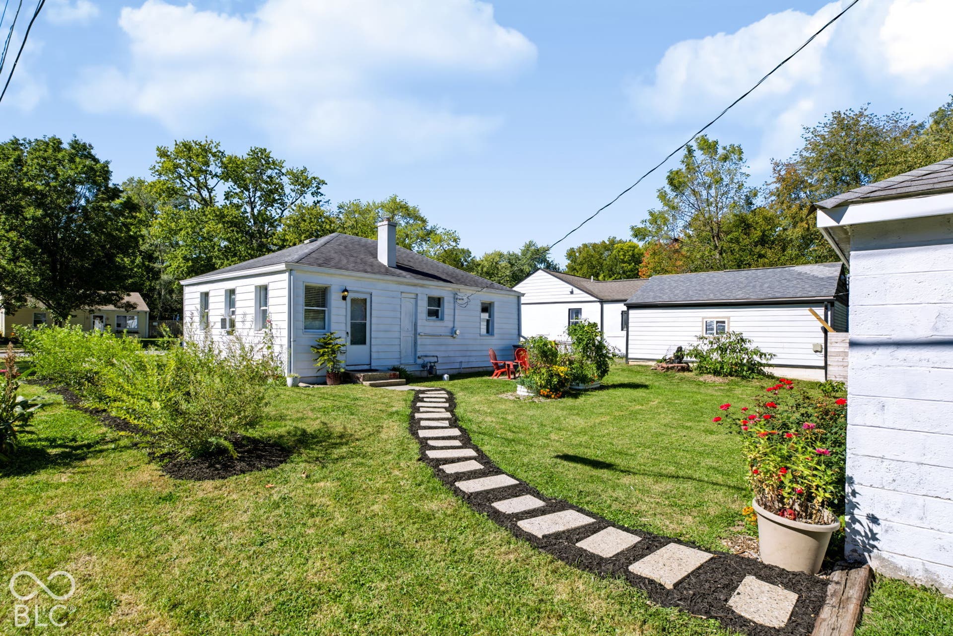 2101 Sharon Avenue, Indianapolis, IN 46222 Expansive green lawn with a stepping stone path, mature trees, and a detached structure