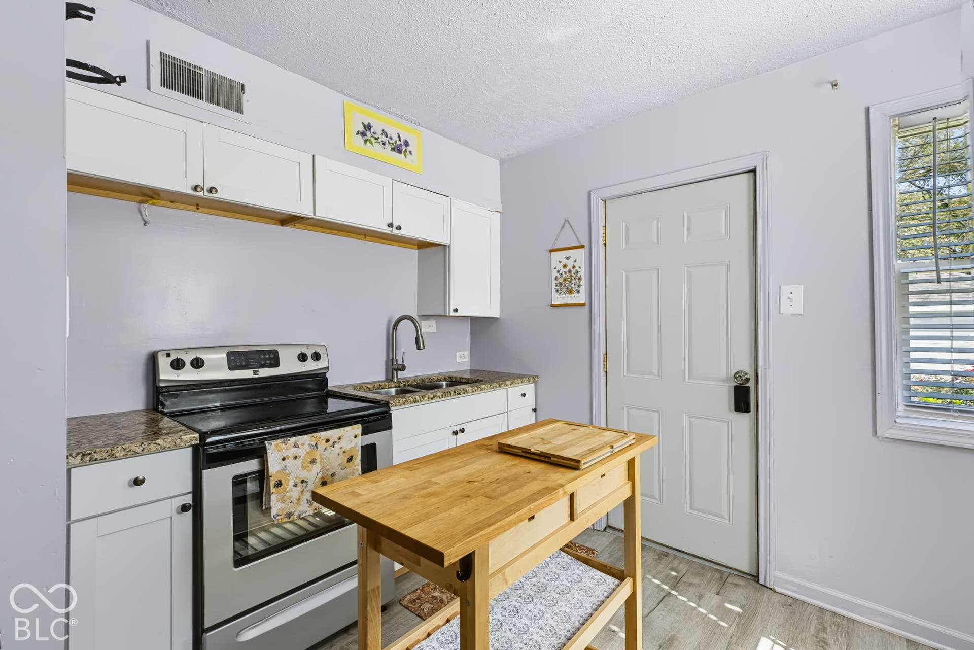 2101 Sharon Avenue, Indianapolis, IN 46222 Kitchen featuring white cabinetry, granite-finish countertops, stainless steel appliances, and light wood-finish flooring