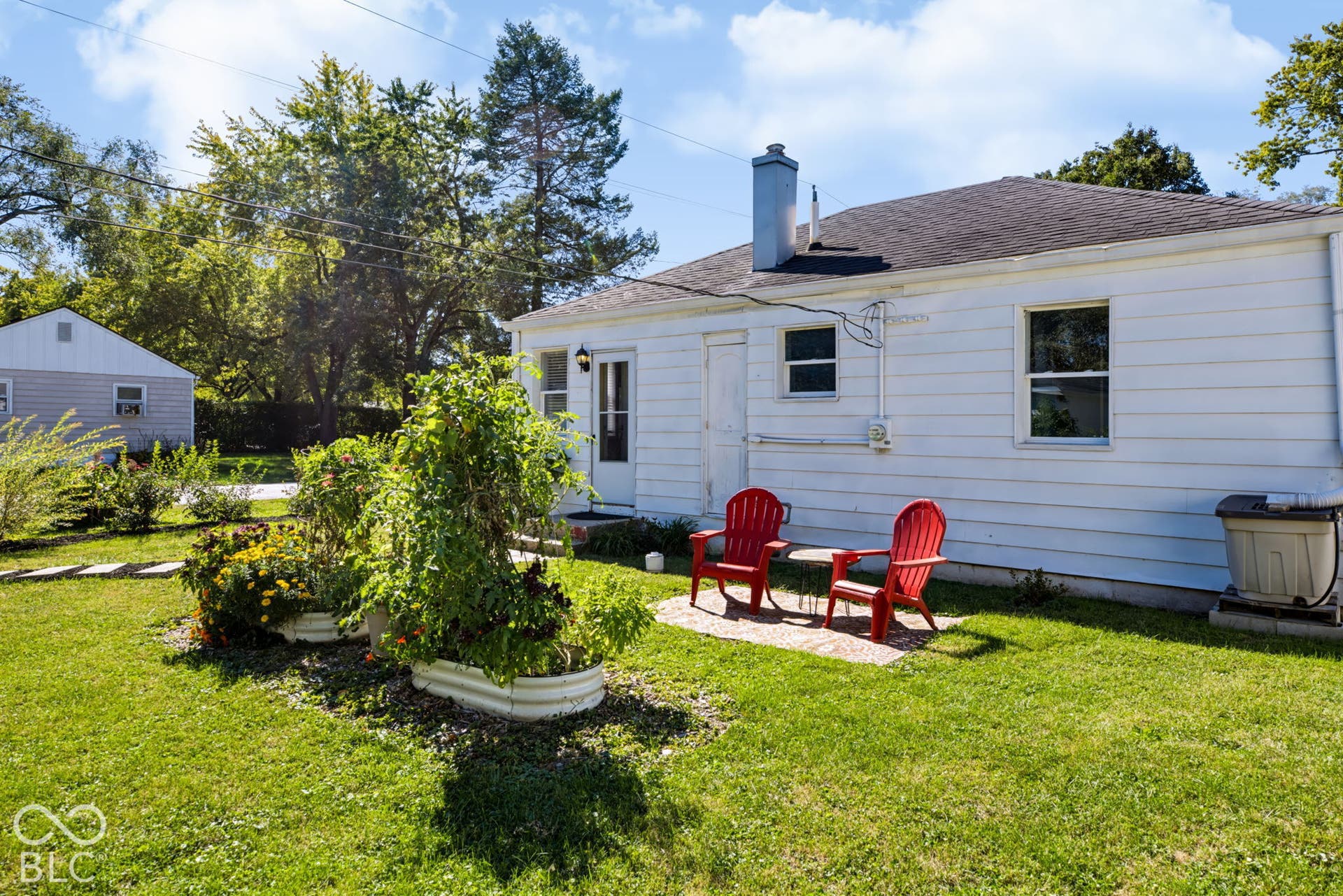 2101 Sharon Avenue, Indianapolis, IN 46222 White siding exterior with a black shingle roof, two distinct windows, and a side entry door