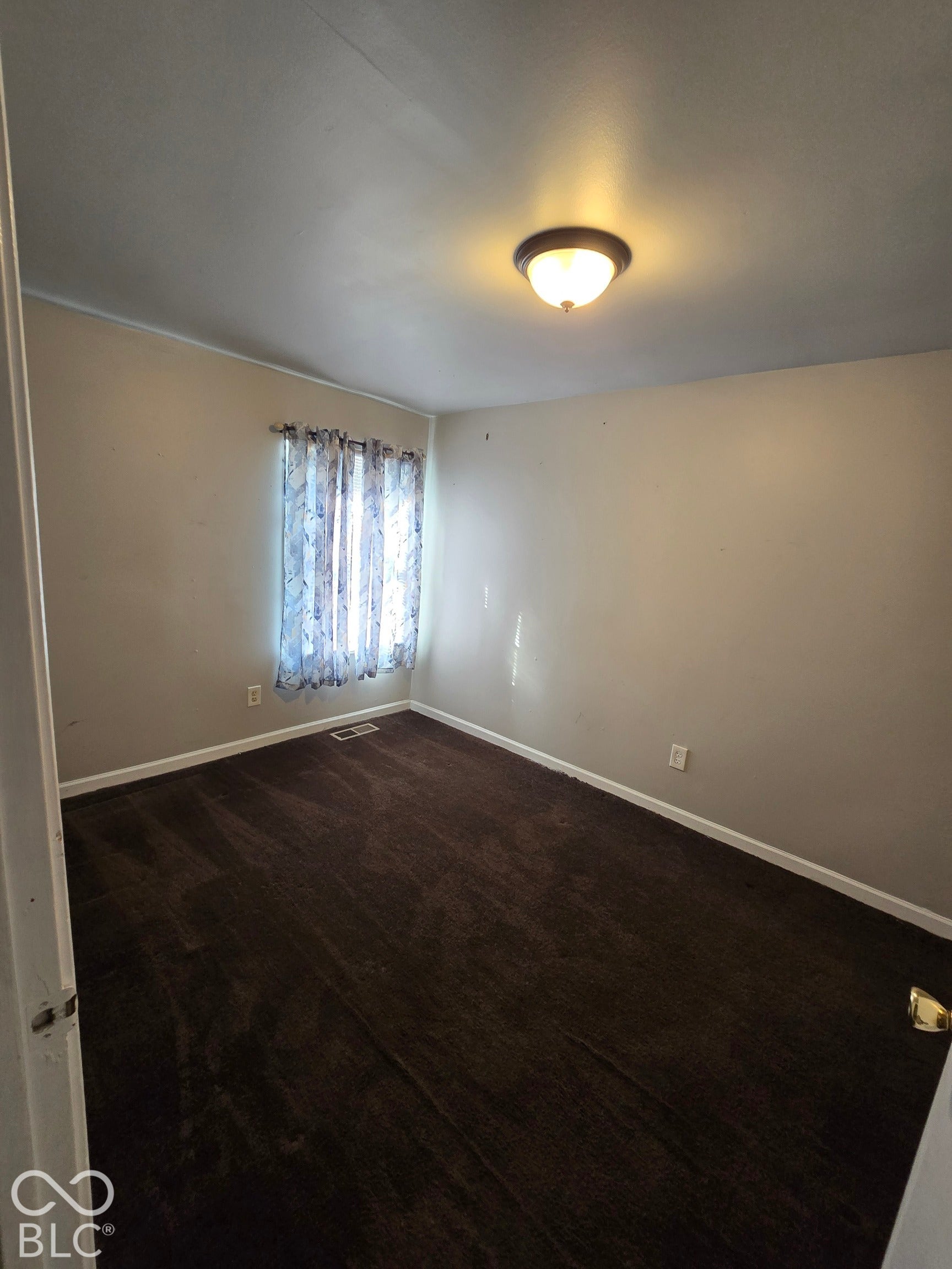 Recessed window with decorative curtain rod, wall-to-wall carpeting, and flush mount ceiling light fixture