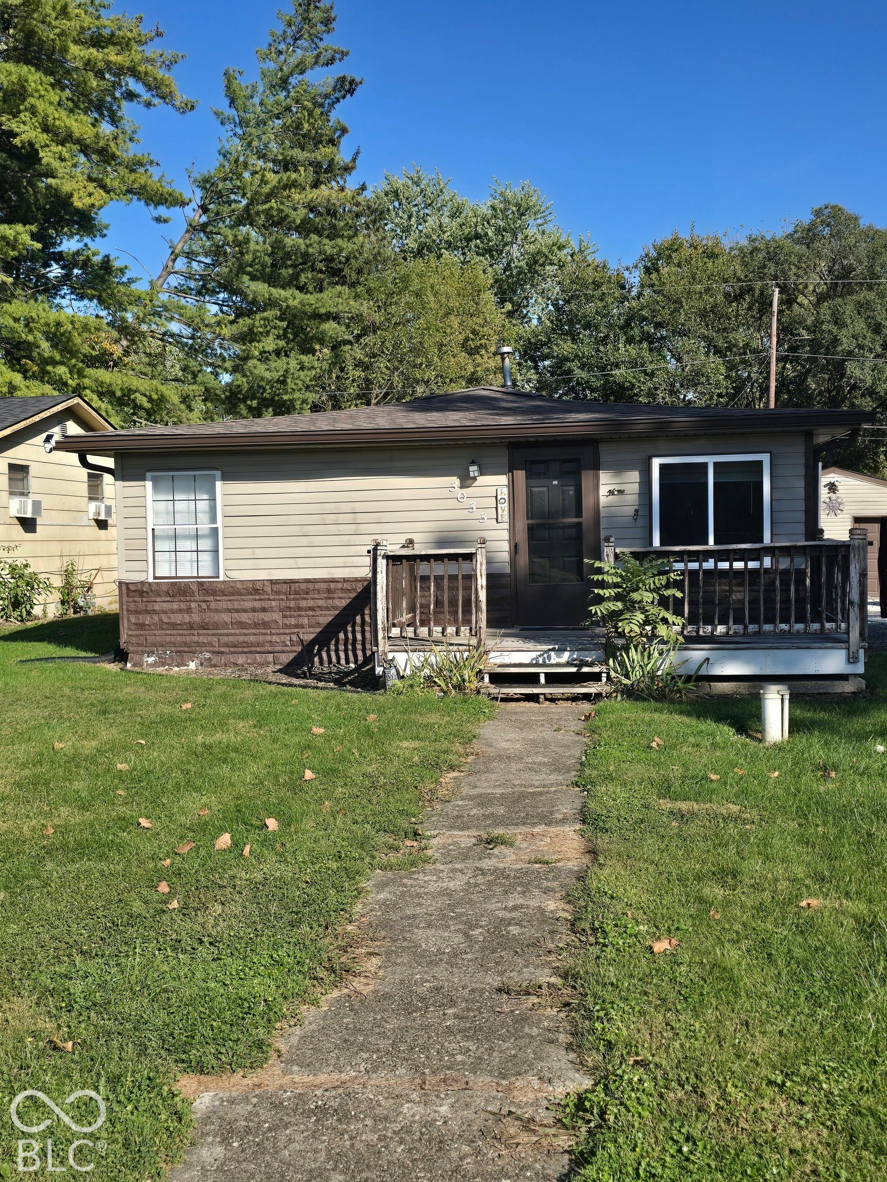 Single-story residence featuring light-colored siding and a dark roof