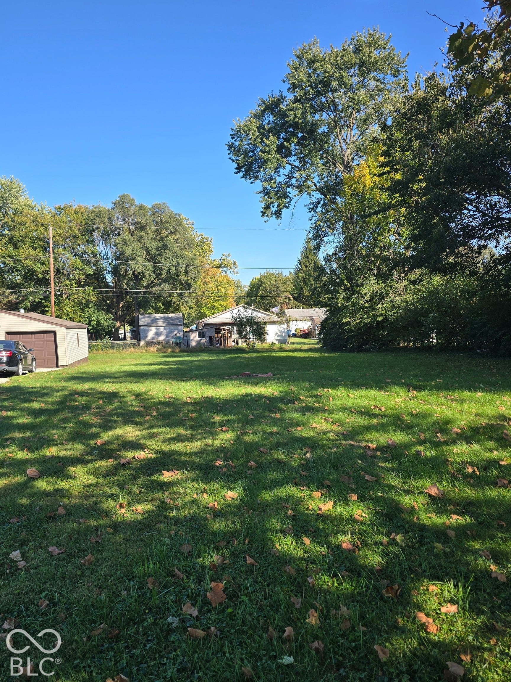 Expansive grassy yard with mature trees