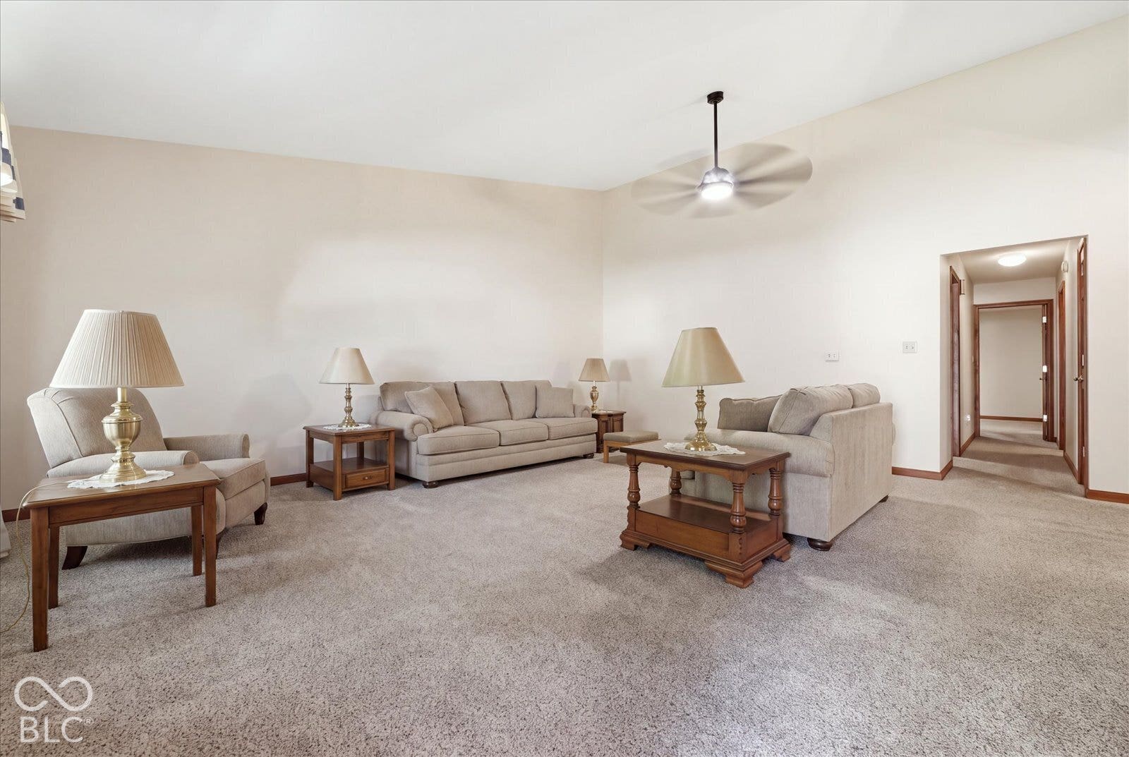 Vaulted ceilings, neutral wall color, and a ceiling fan with integrated lighting