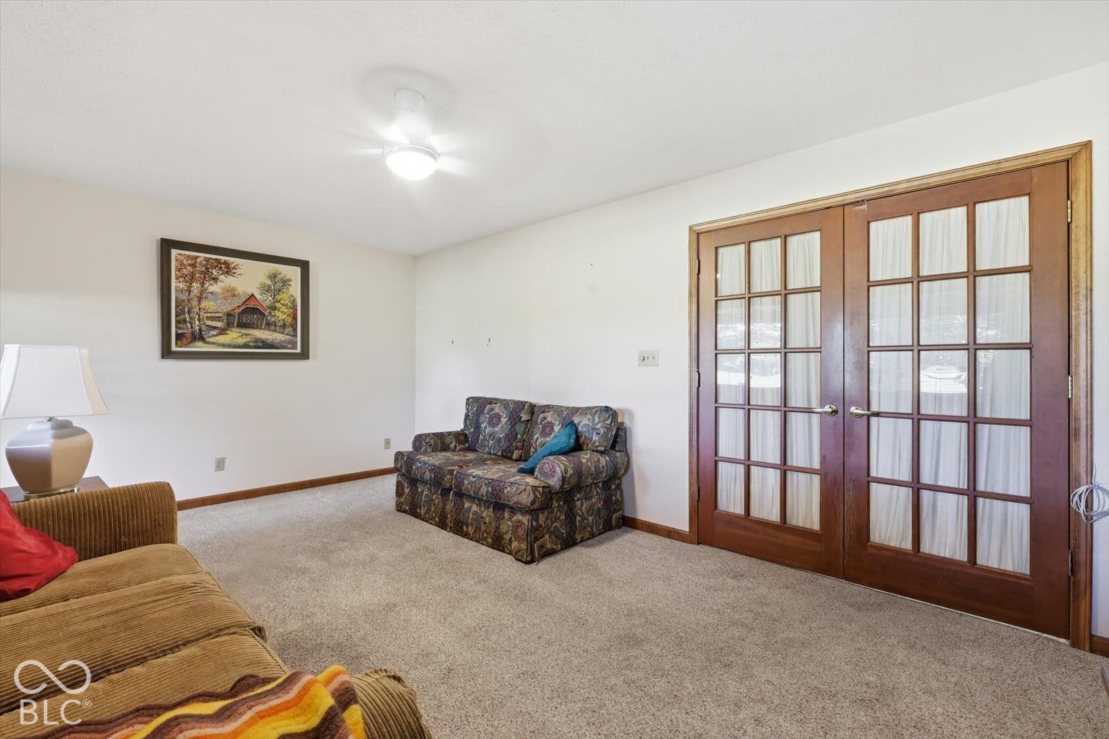 Sun Room featuring neutral-toned carpeting, wood-frame French doors, and a ceiling-mounted light fixture