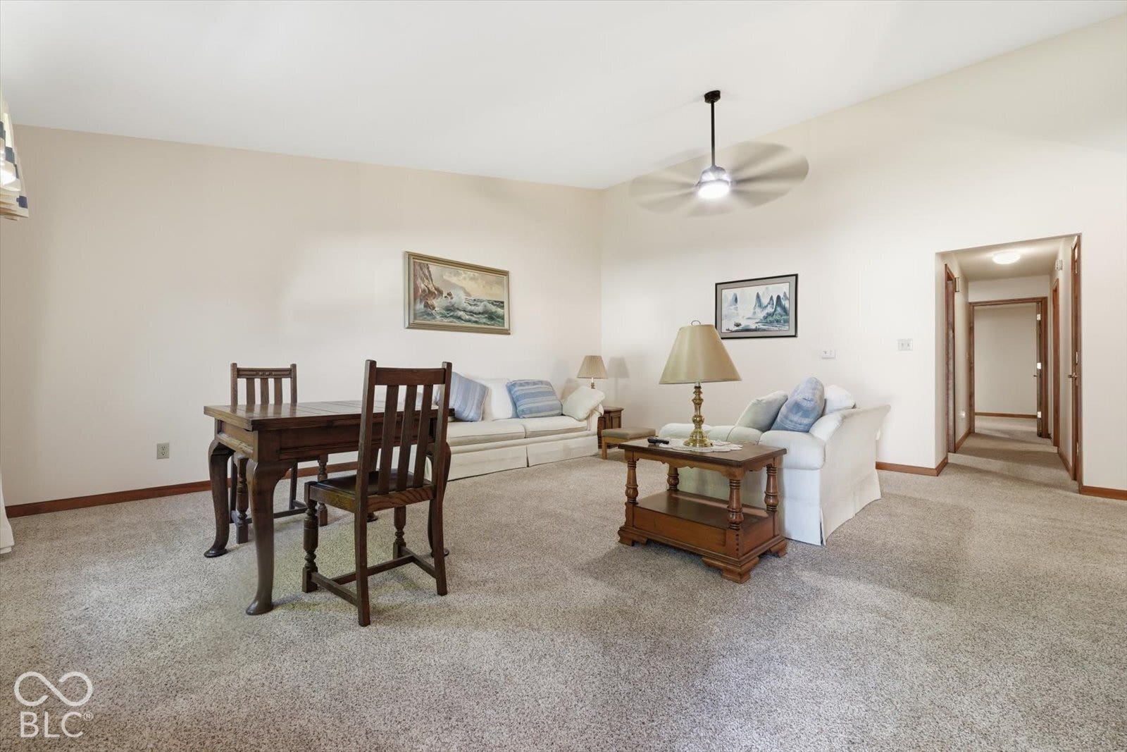 Vaulted ceiling, ceiling fan, and neutral carpeting