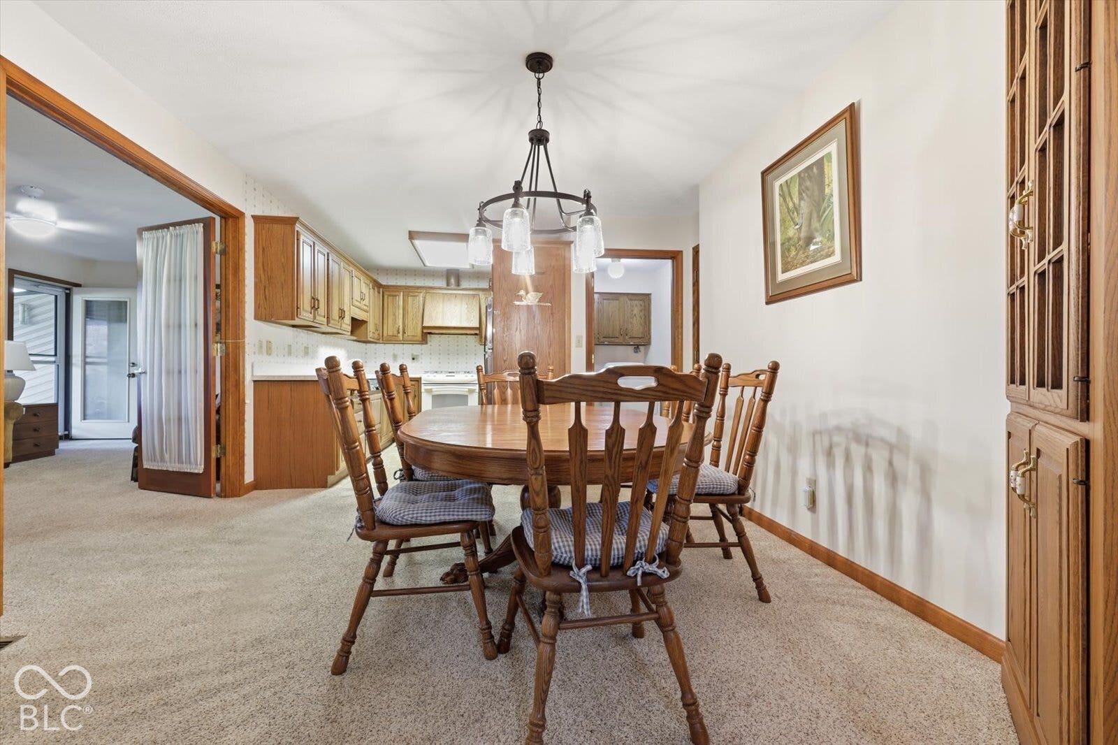 Dining area featuring a chandelier, built-in floor-to-ceiling cabinetry, and neutral carpeting