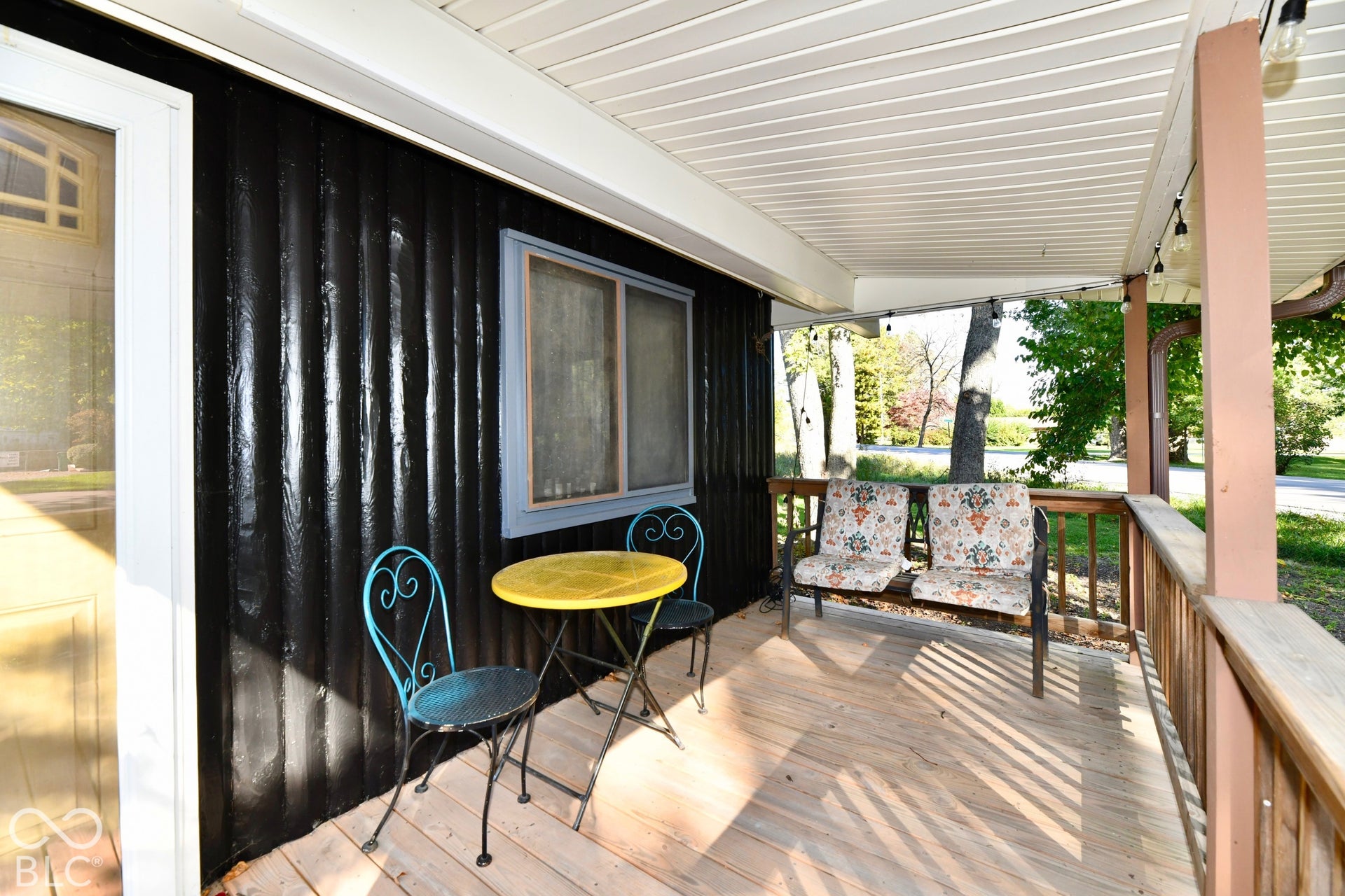 Covered porch featuring a wood deck, wood railings, and a white ceiling