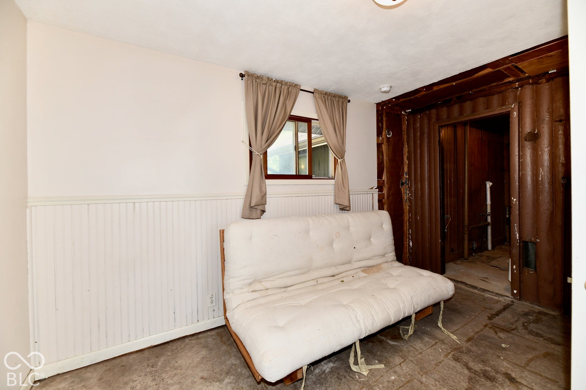 Third Bedroom featuring wood-paneled walls, light colored paint, and carpeted flooring