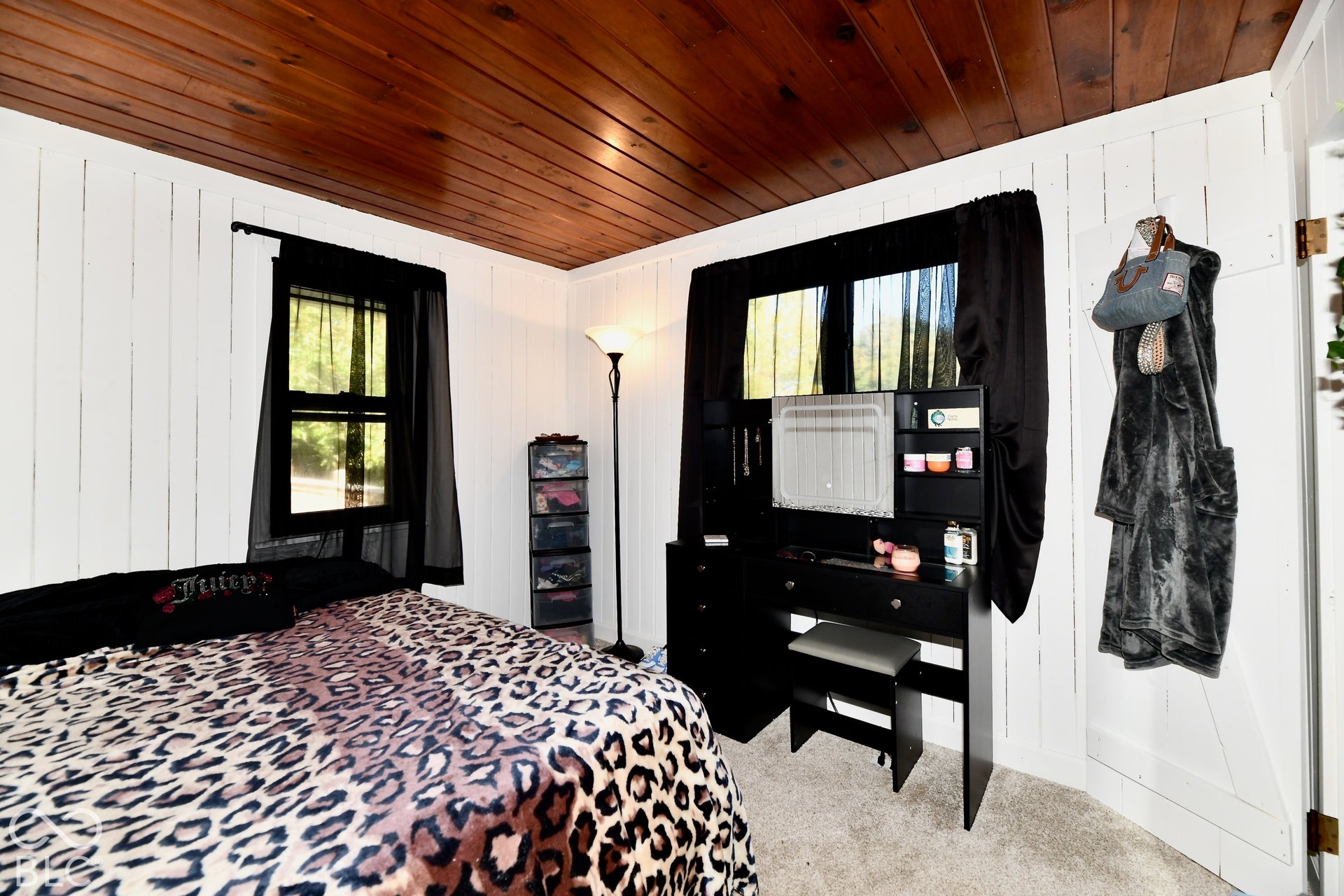 Wood-paneled ceiling, vertical plank wall treatment, double-hung window, and carpeted flooring