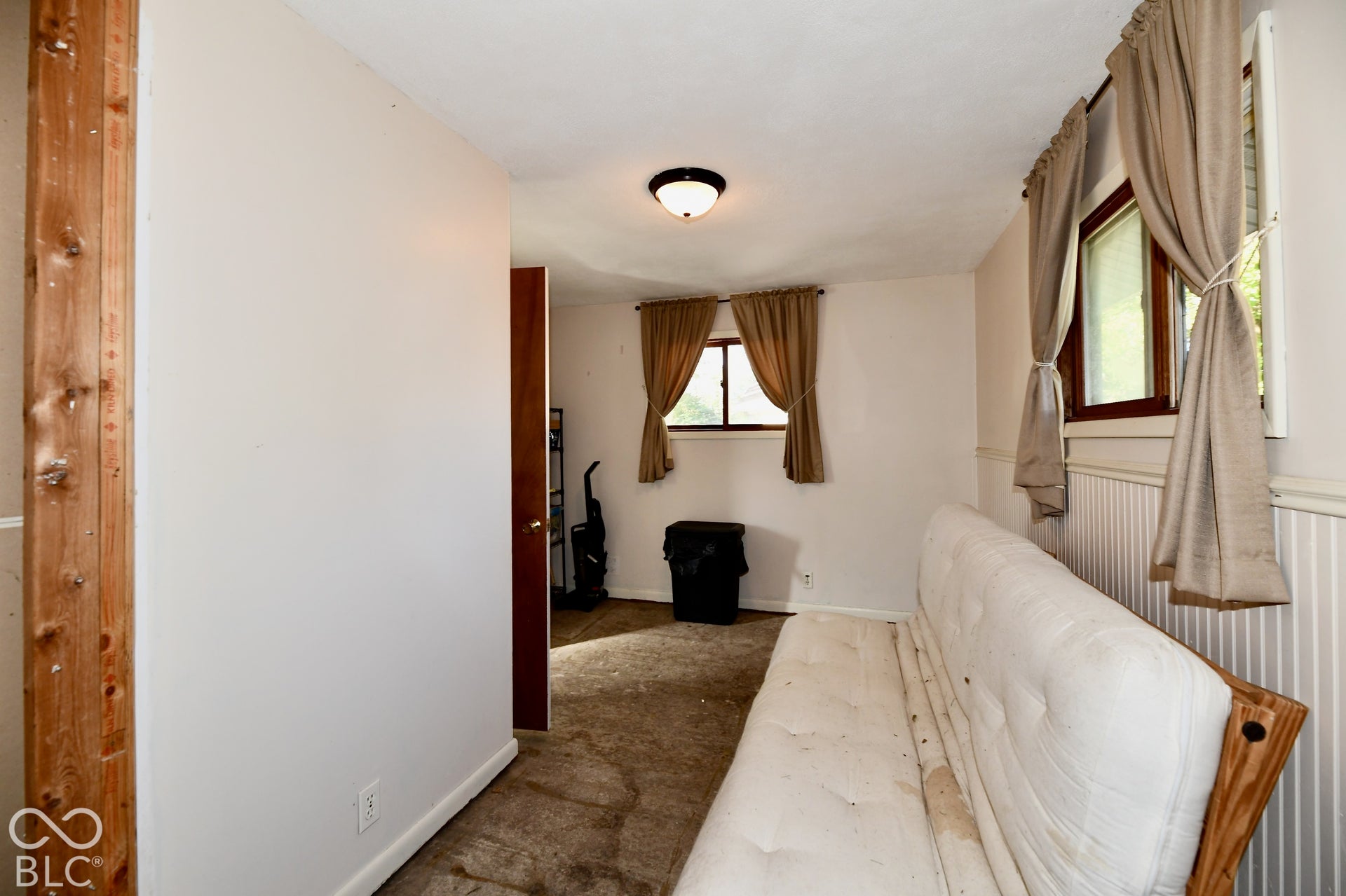 Third bedroom featuring two windows, light colored walls, and carpeted flooring