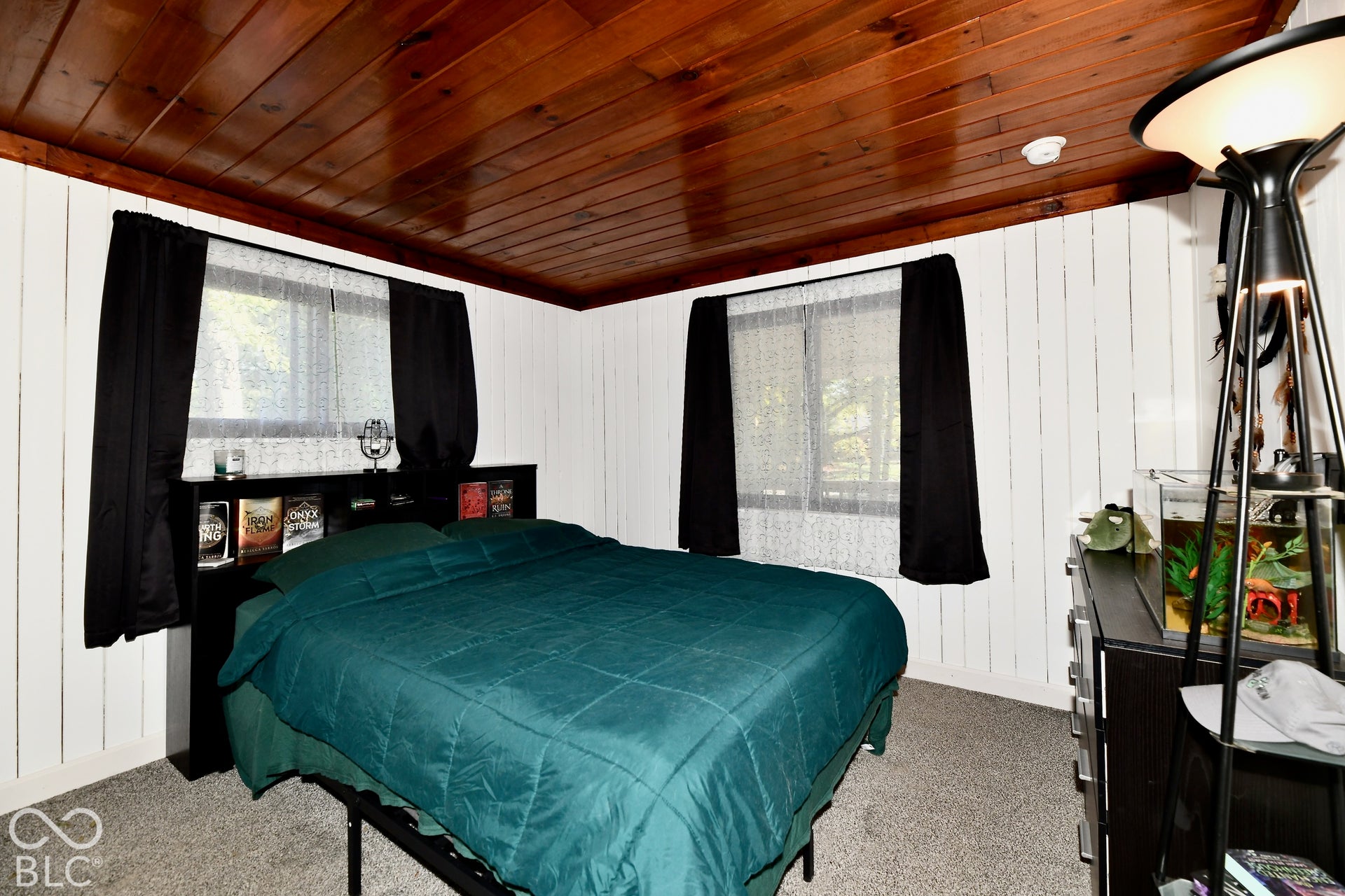 Wood-paneled ceiling with a warm finish, contrasting with white vertical wall paneling