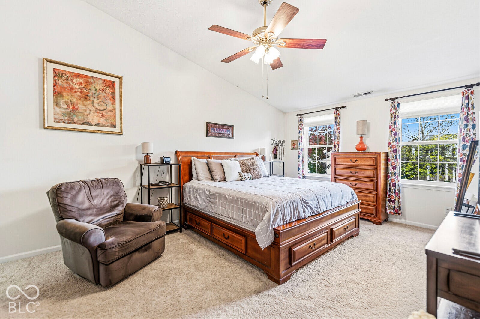 Vaulted ceilings, multi-pane windows, and a ceiling fan with integrated lighting