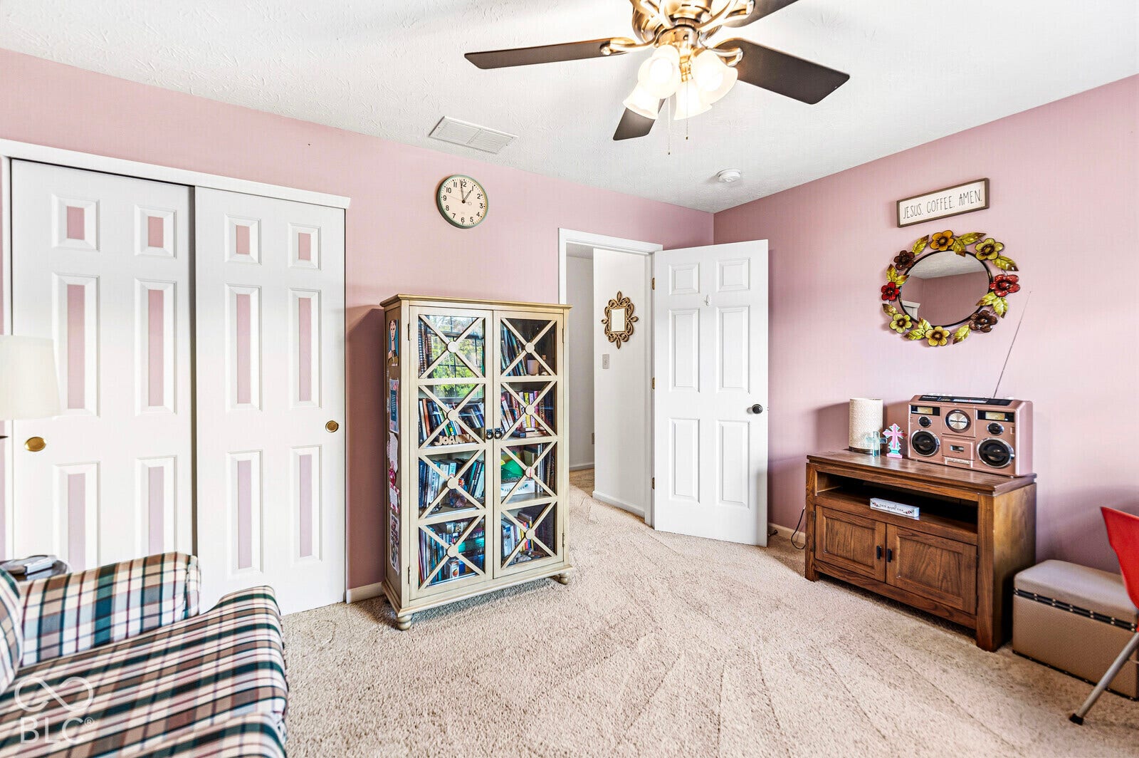 Interior room featuring wall-to-wall carpeting, a multi-light ceiling fan, and a built-in sliding door closet with panel detailing