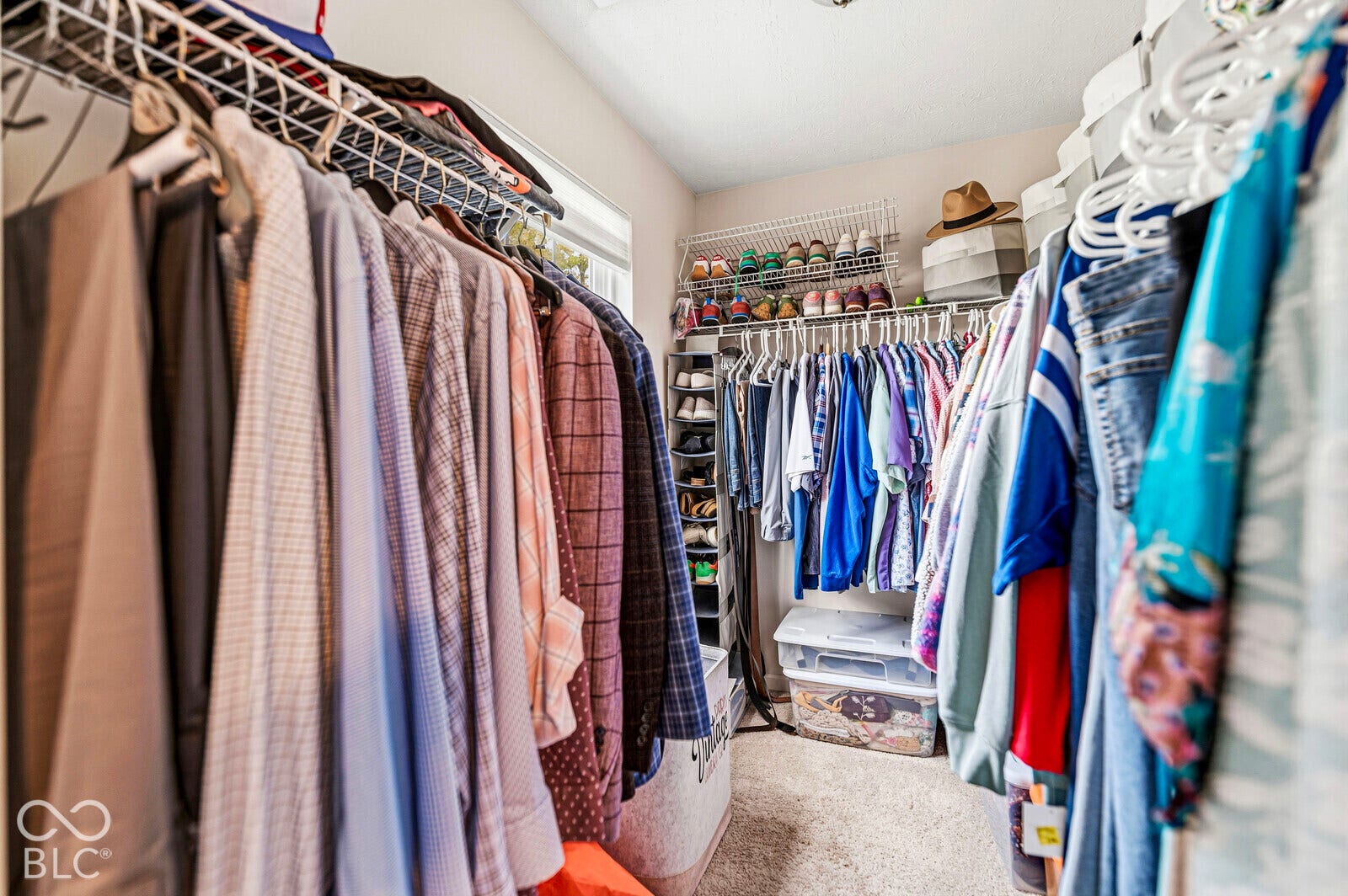Walk-in closet featuring multi-tiered wire shelving and integrated vertical shoe storage