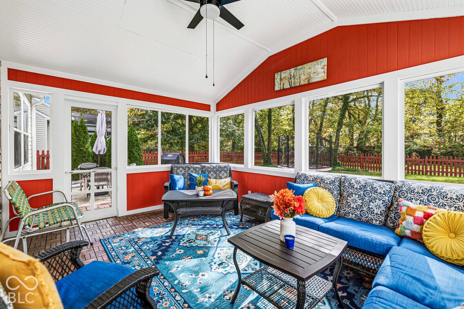 Enclosed sunroom featuring a vaulted beadboard ceiling, ceiling fan, brick flooring, and large windows with outdoor exposure