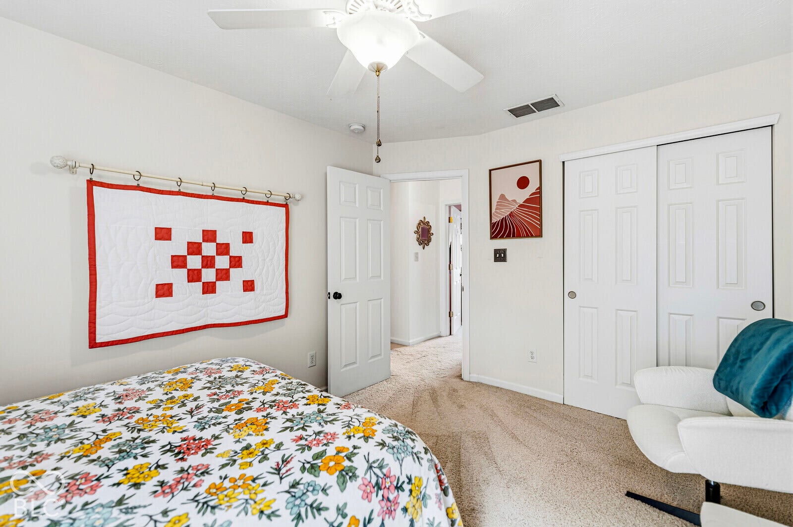 Neutral interior space featuring carpeted flooring, a ceiling fan with integrated lighting, and a dual-panel sliding closet door