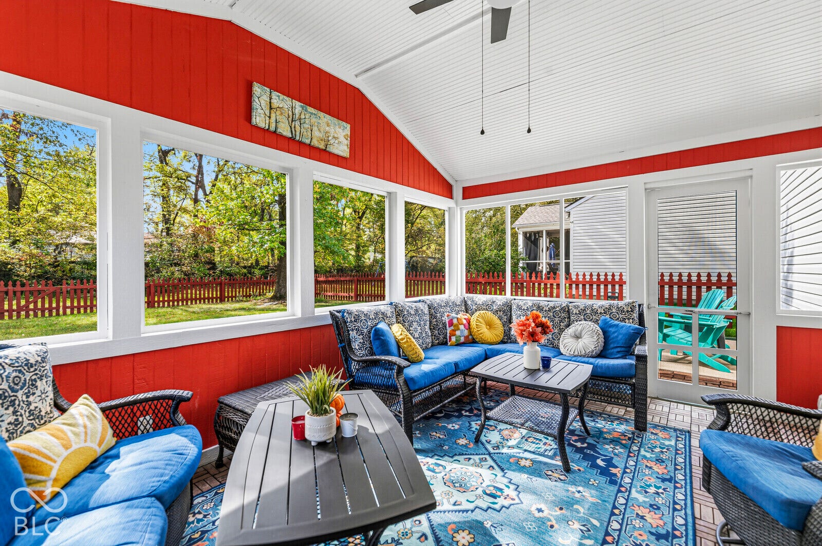 Enclosed porch featuring tongue-and-groove paneled walls, a vaulted ceiling with a mounted fan, extensive window spans, and brick-style flooring