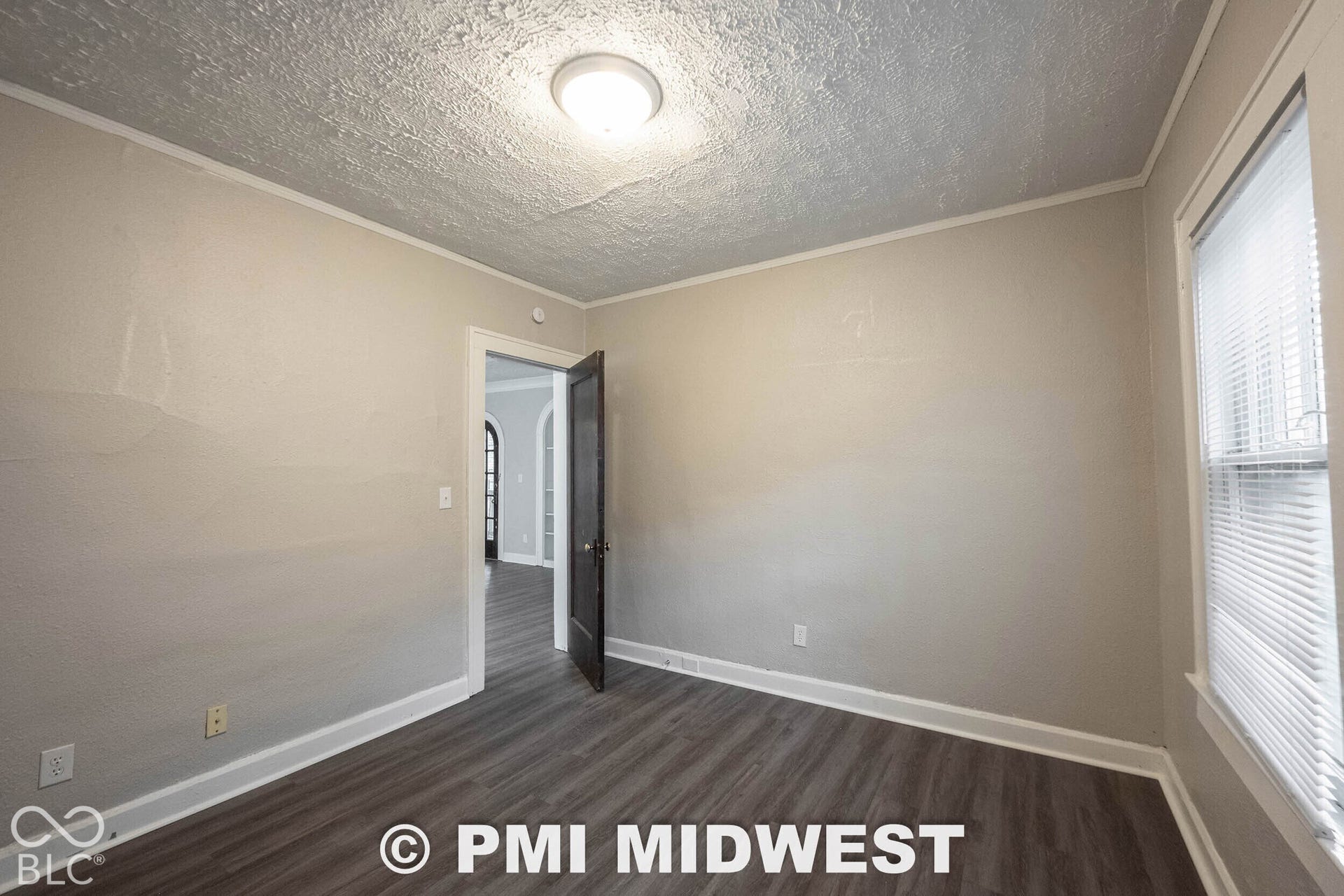Recessed ceiling light, wood-finish flooring, light-toned walls, white trim, and a window with blinds