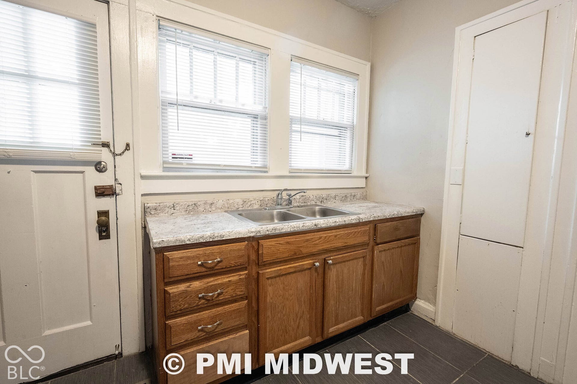 Wood-finish cabinetry with a laminate countertop and dual basin sink