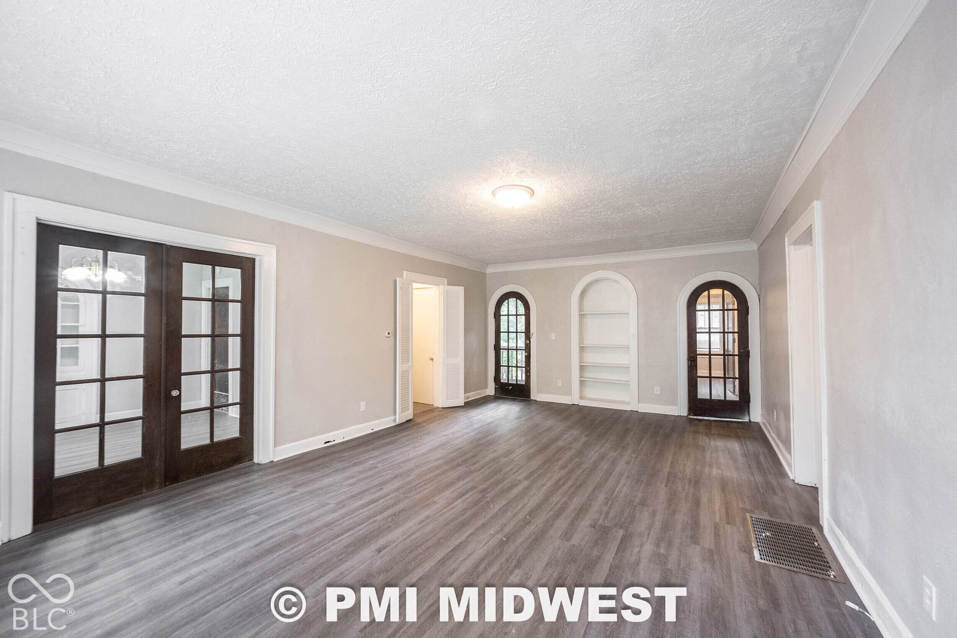 Wood-finish flooring throughout, paired with light-toned walls and crown molding