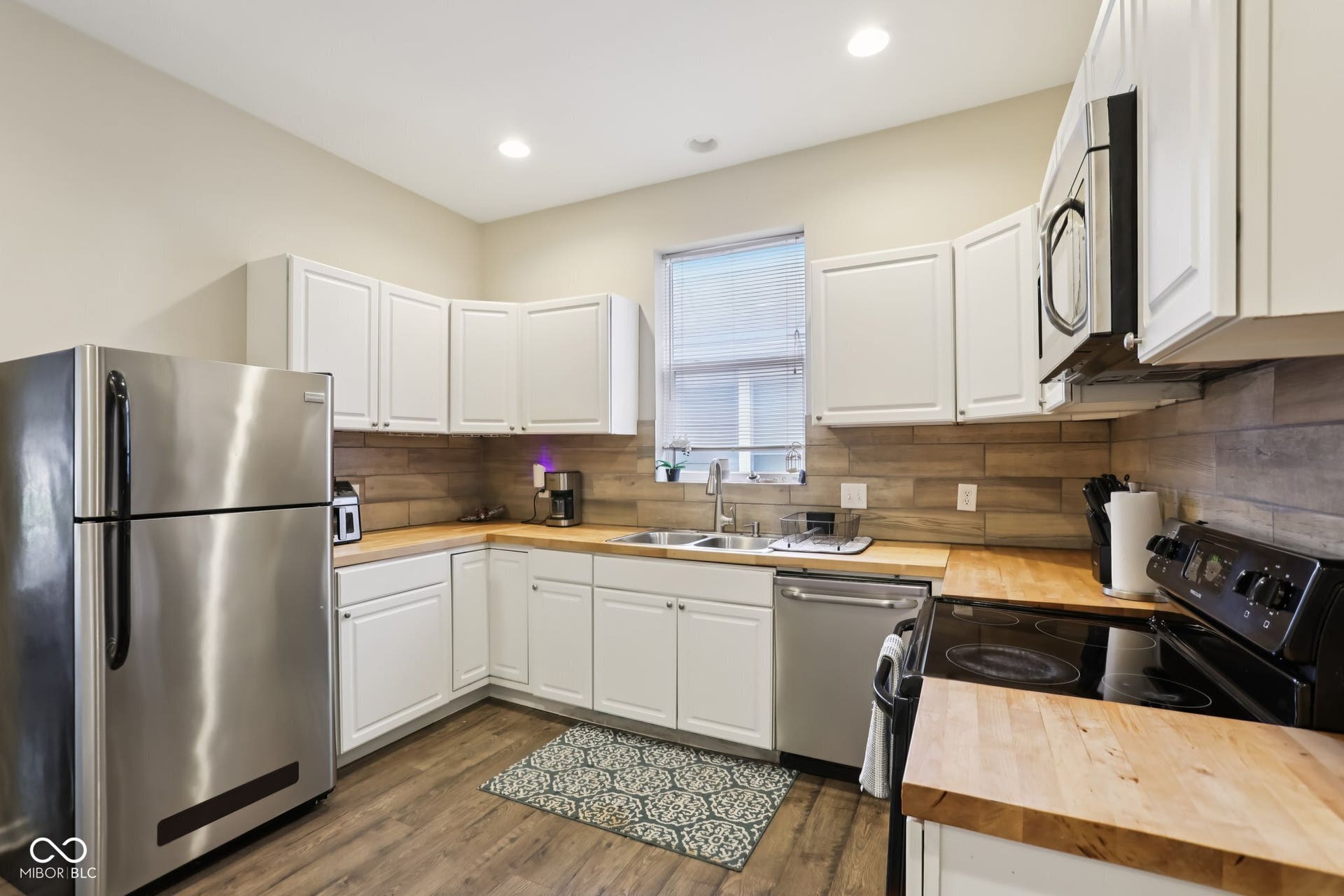 729 E Morris Street, Indianapolis, IN 46203 kitchen with stainless steel appliances, white cabinets, wood counters, and recessed lighting