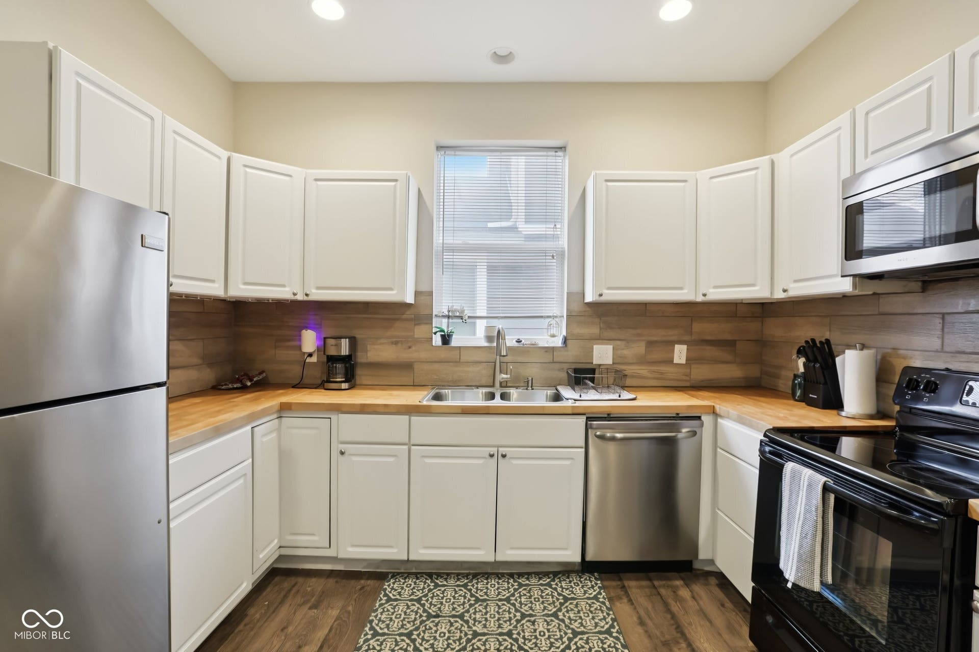 729 E Morris Street, Indianapolis, IN 46203 kitchen featuring stainless steel appliances, white cabinetry, dark wood-style floors, butcher block counters, and recessed lighting