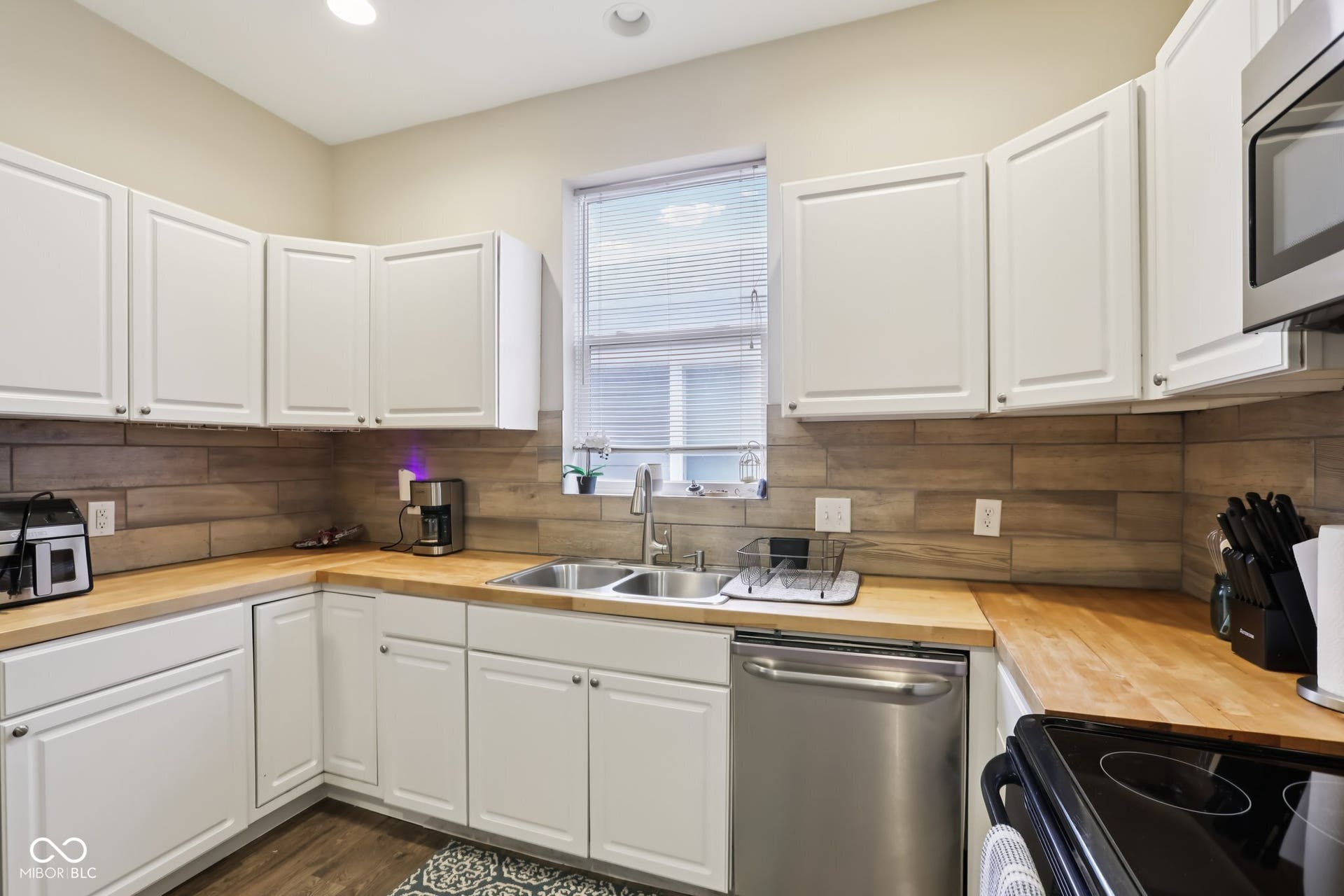 729 E Morris Street, Indianapolis, IN 46203 kitchen with wooden counters, stainless steel appliances, and white cabinetry