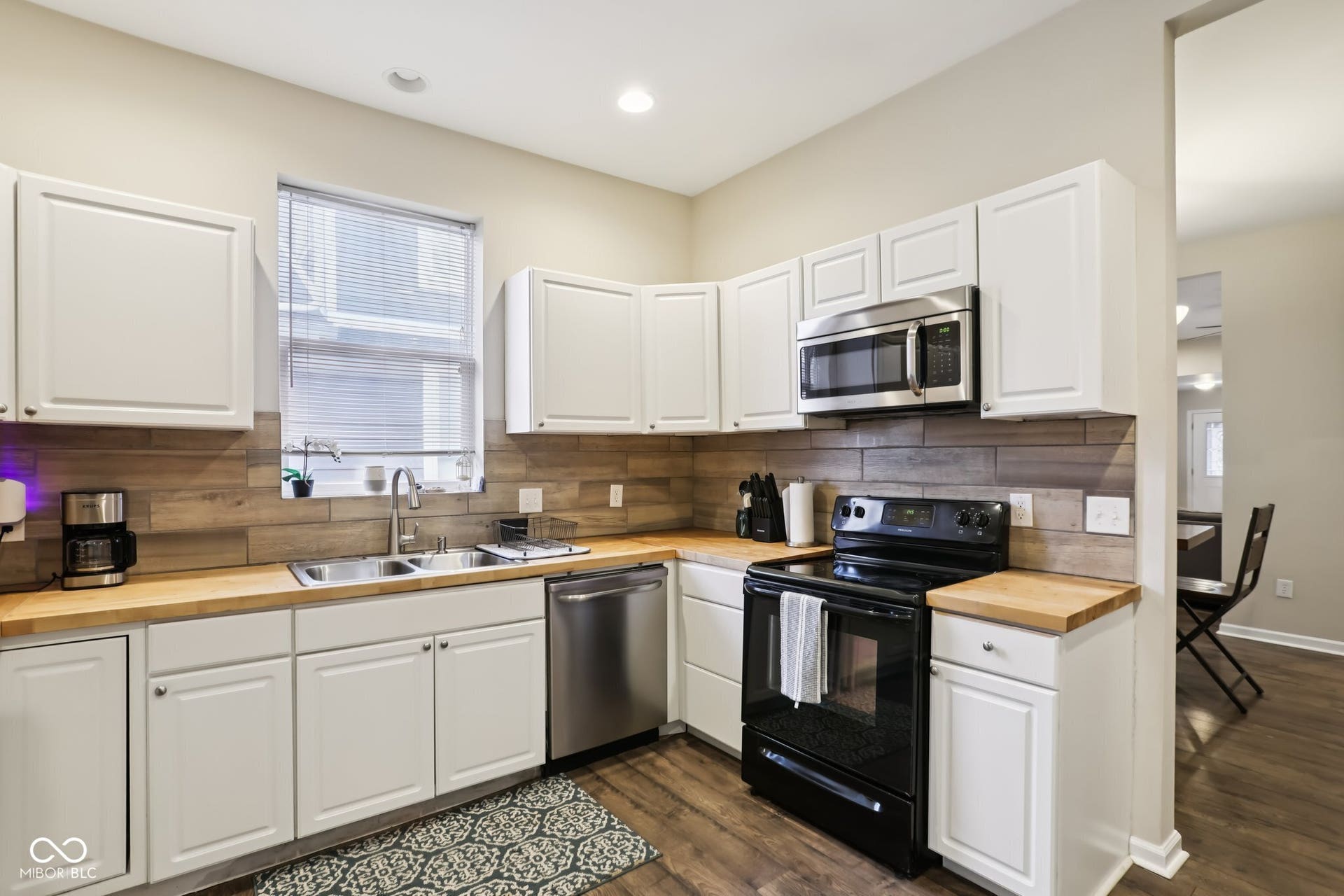 729 E Morris Street, Indianapolis, IN 46203 kitchen featuring wood counters, stainless steel appliances, white cabinets, and dark wood-type flooring