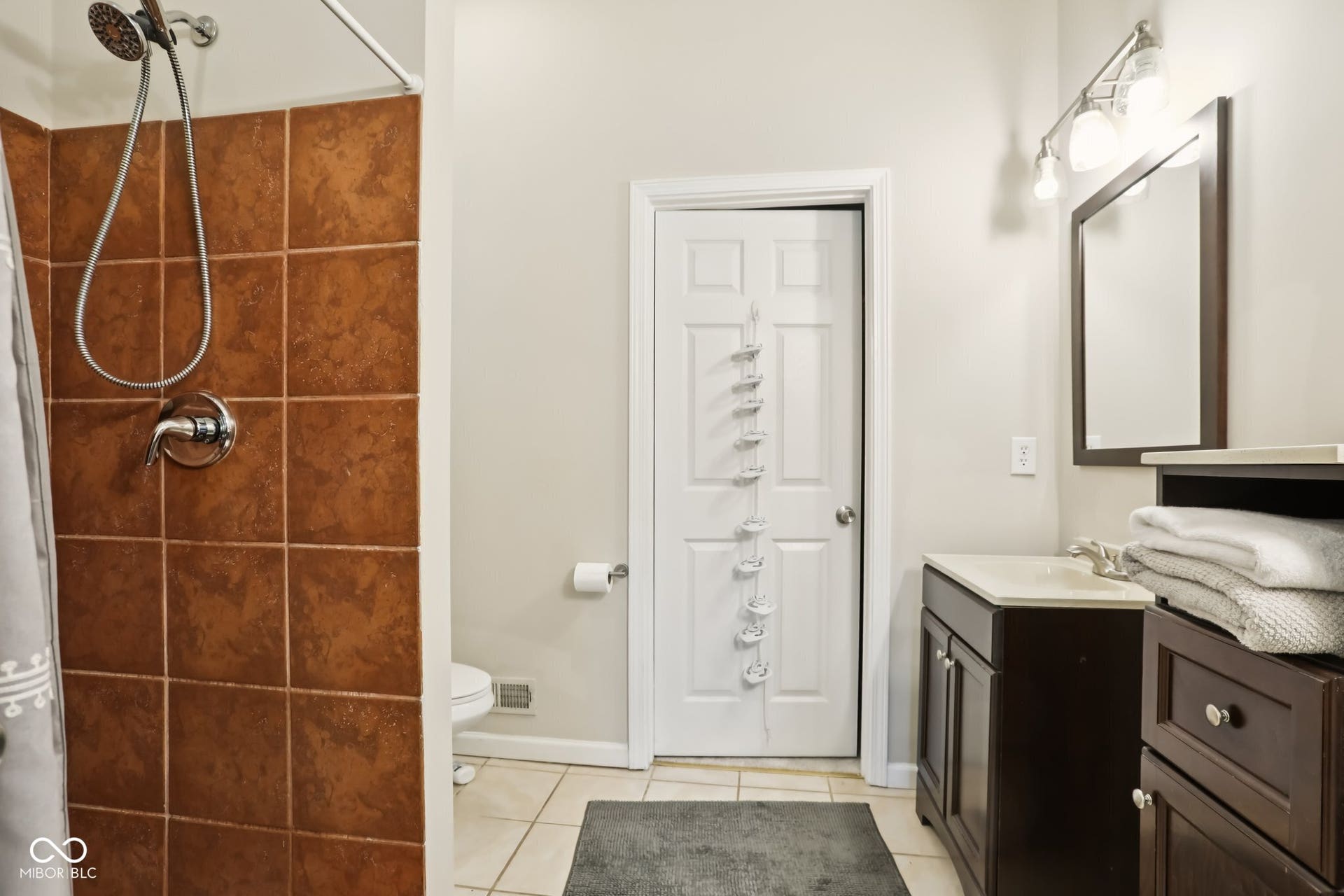 729 E Morris Street, Indianapolis, IN 46203 bathroom featuring vanity, tiled shower, and light tile patterned floors
