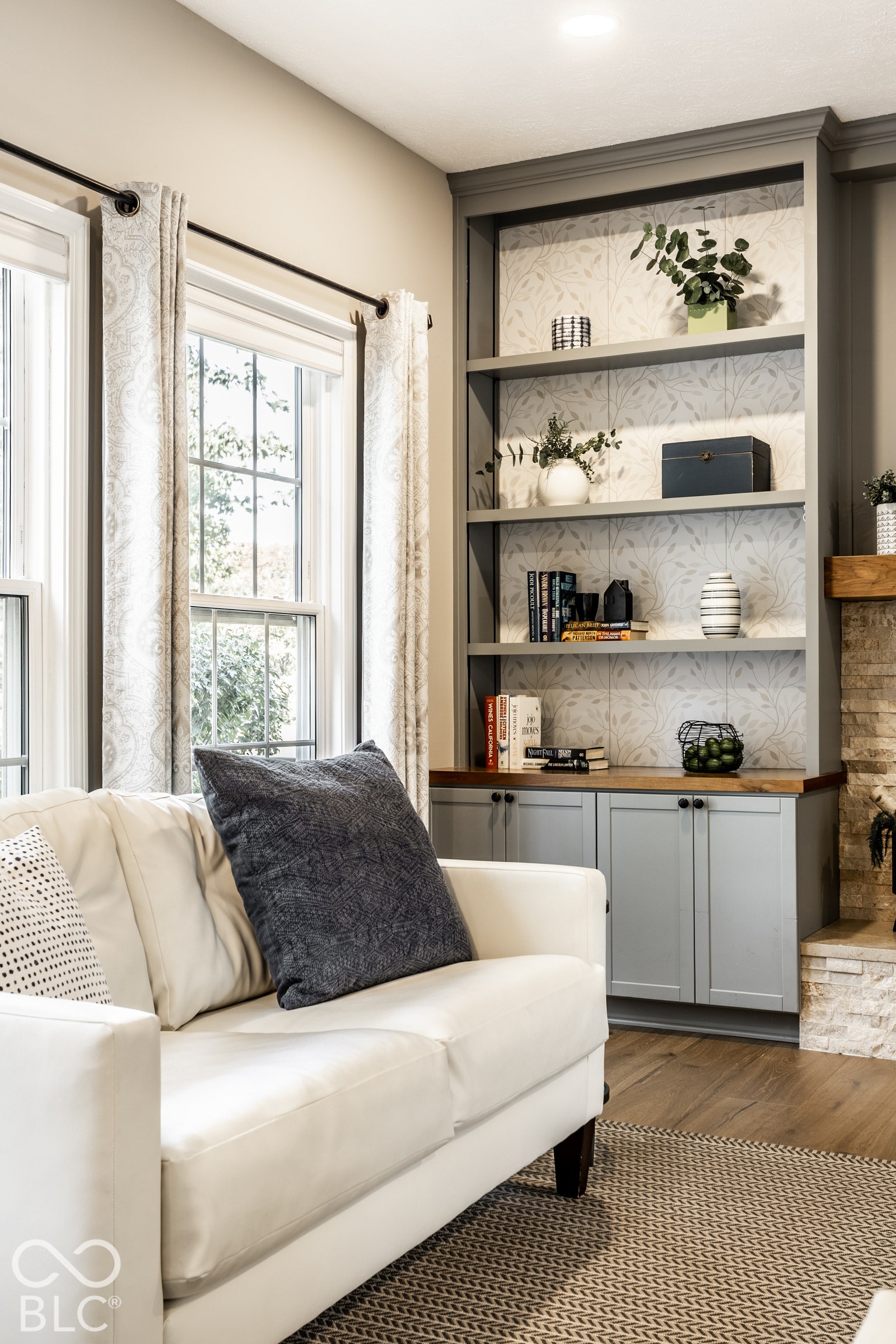 Built-in shelving with decorative backing, lower cabinetry with wood-finish countertop, recessed ceiling lighting, and wood-finish flooring