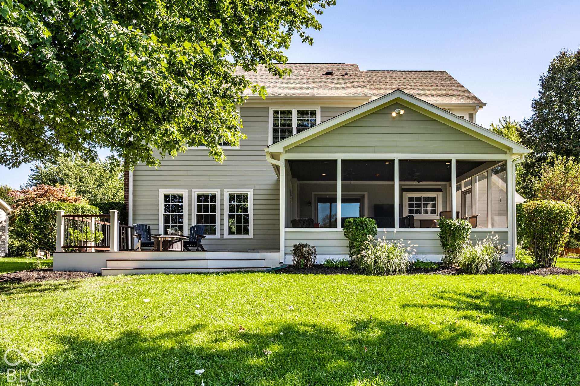 Screened porch, exterior siding, multi-pane windows, composite deck, and mature landscaping