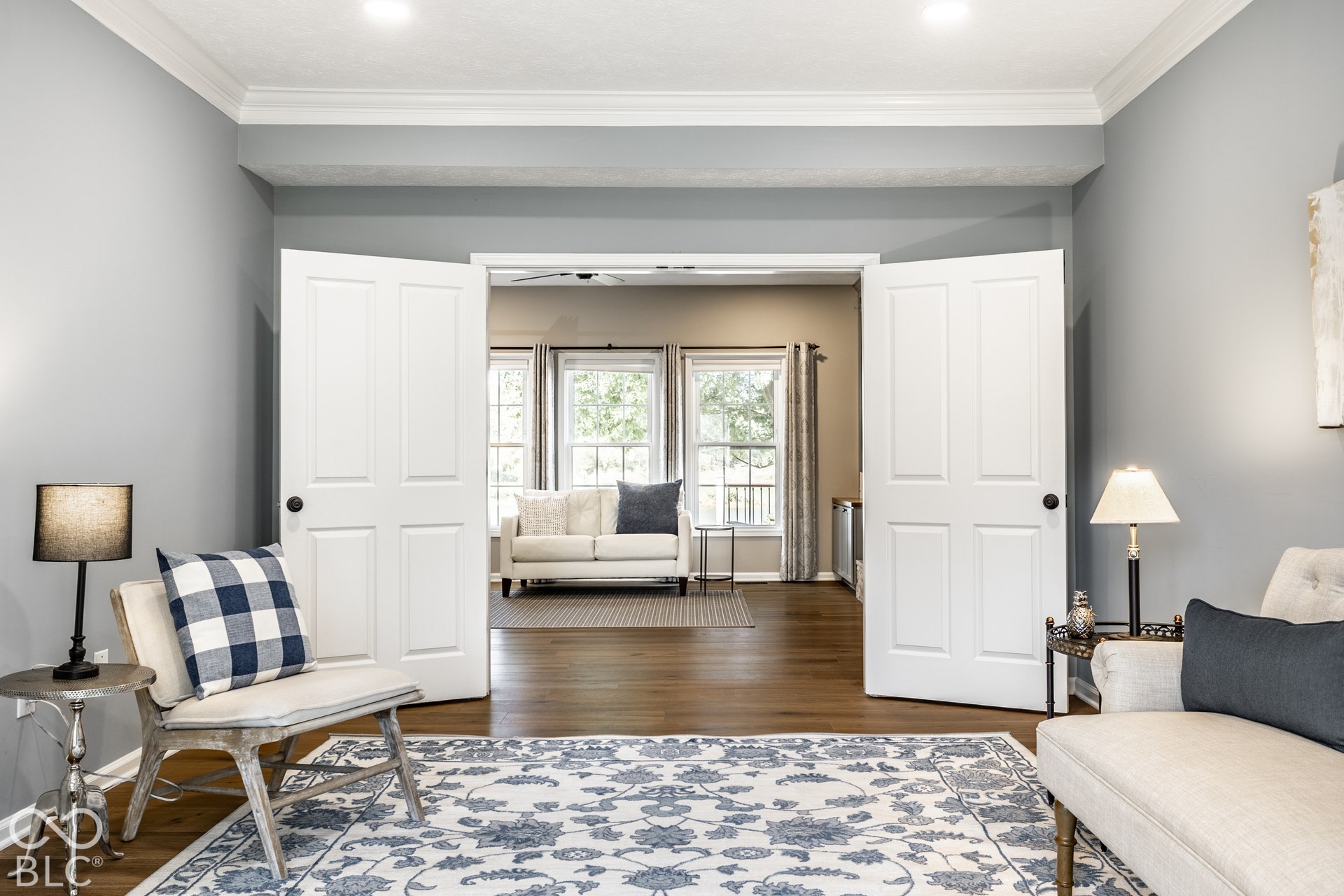 Double-panel doors open to a space featuring crown molding, recessed lighting, and wood-finish flooring
