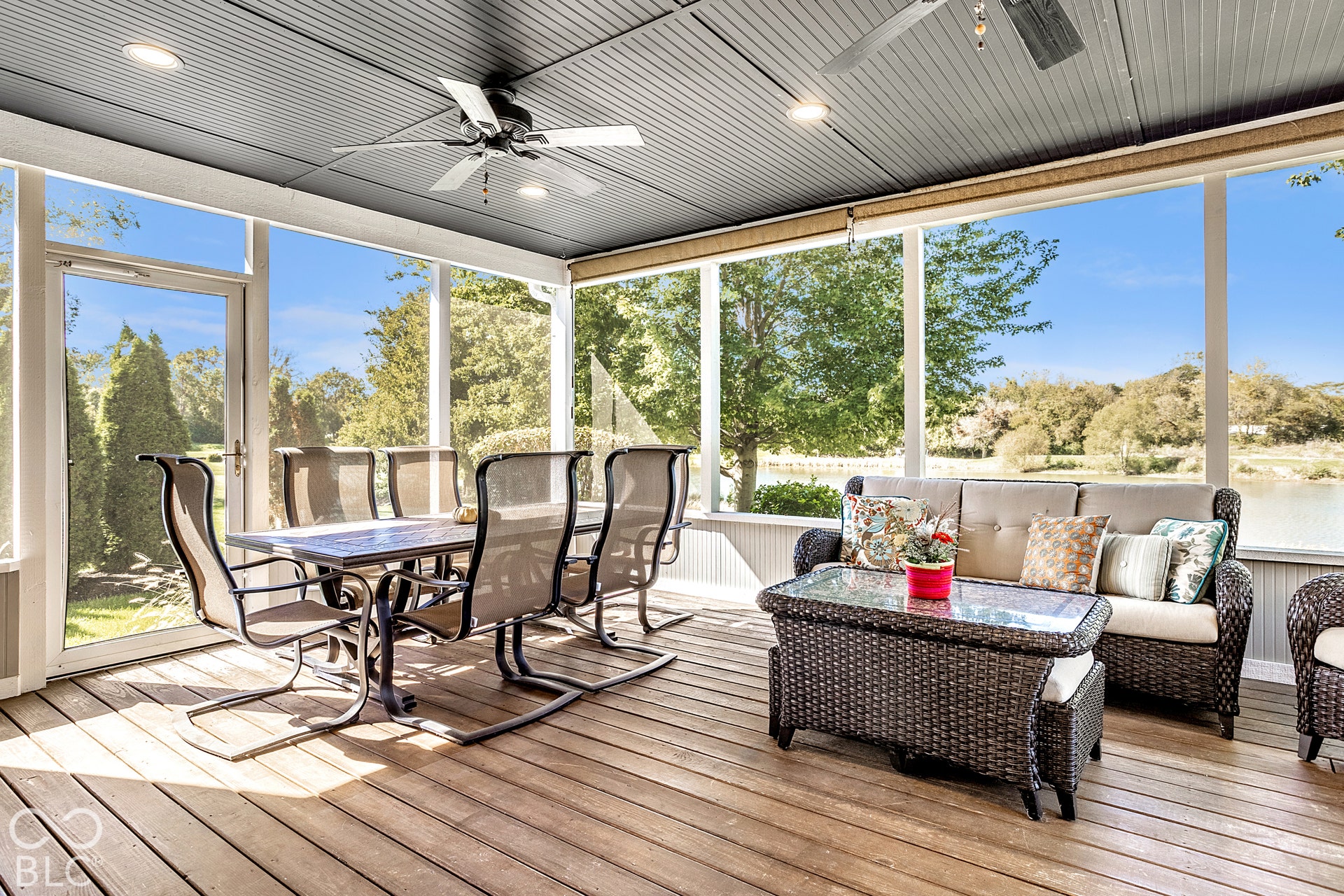 Screened porch with wood-finish flooring, ceiling fans, recessed lighting, and expansive outdoor exposure