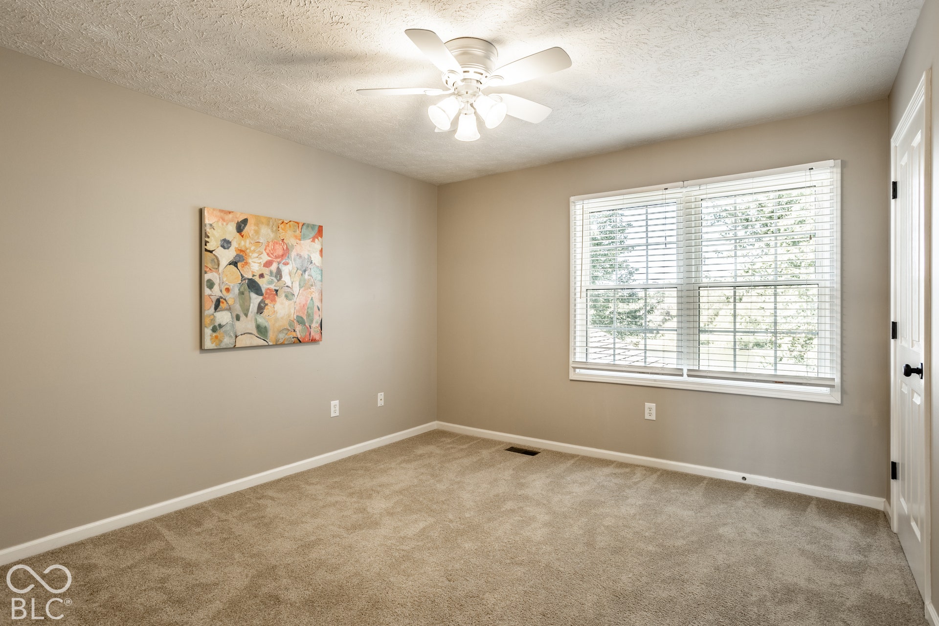 Recessed window with white blinds and trim, textured ceiling, ceiling fan with integrated lighting, neutral wall paint, and wall-to-wall carpeting