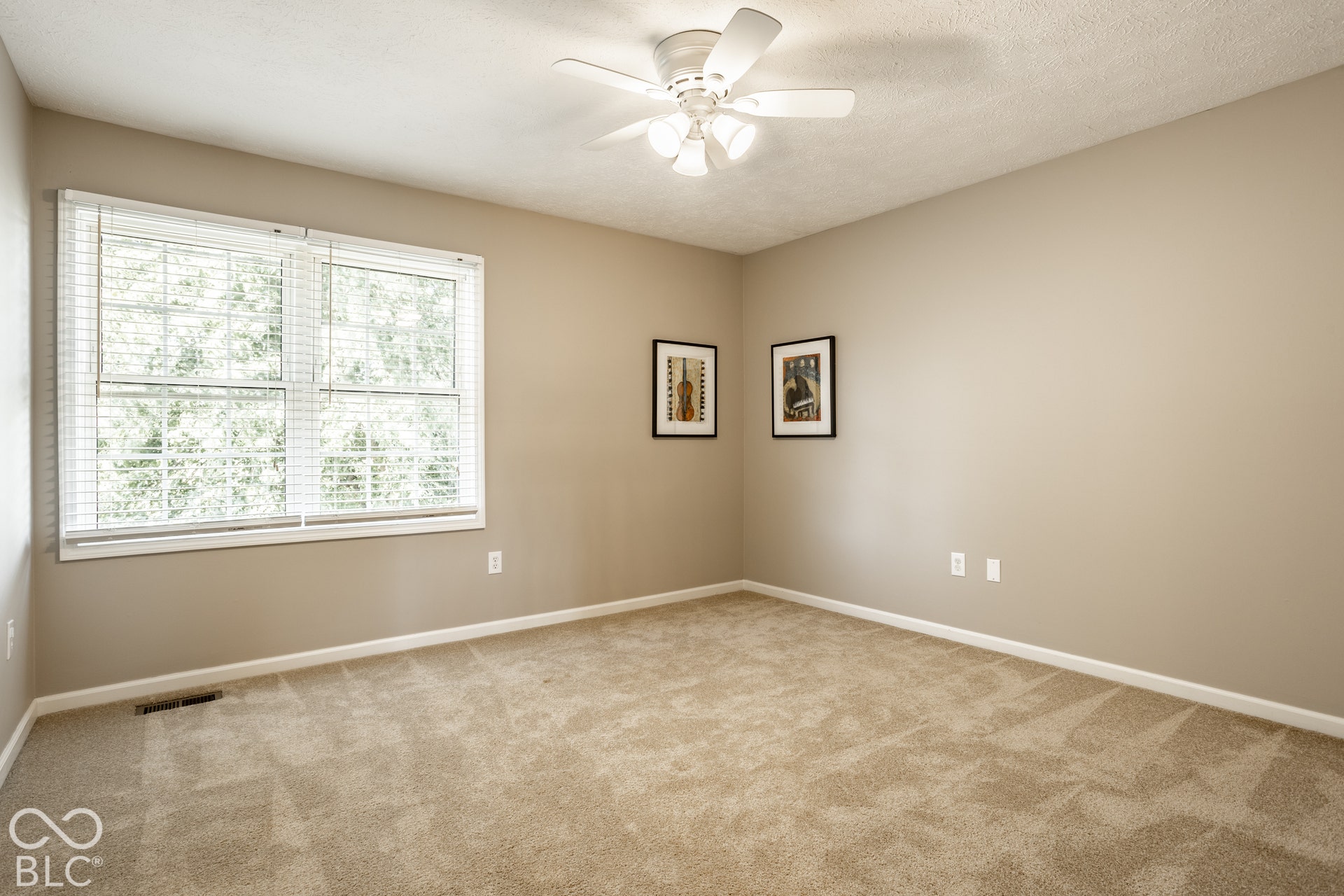 Wall-to-wall carpeting and a ceiling fan with integrated lighting
