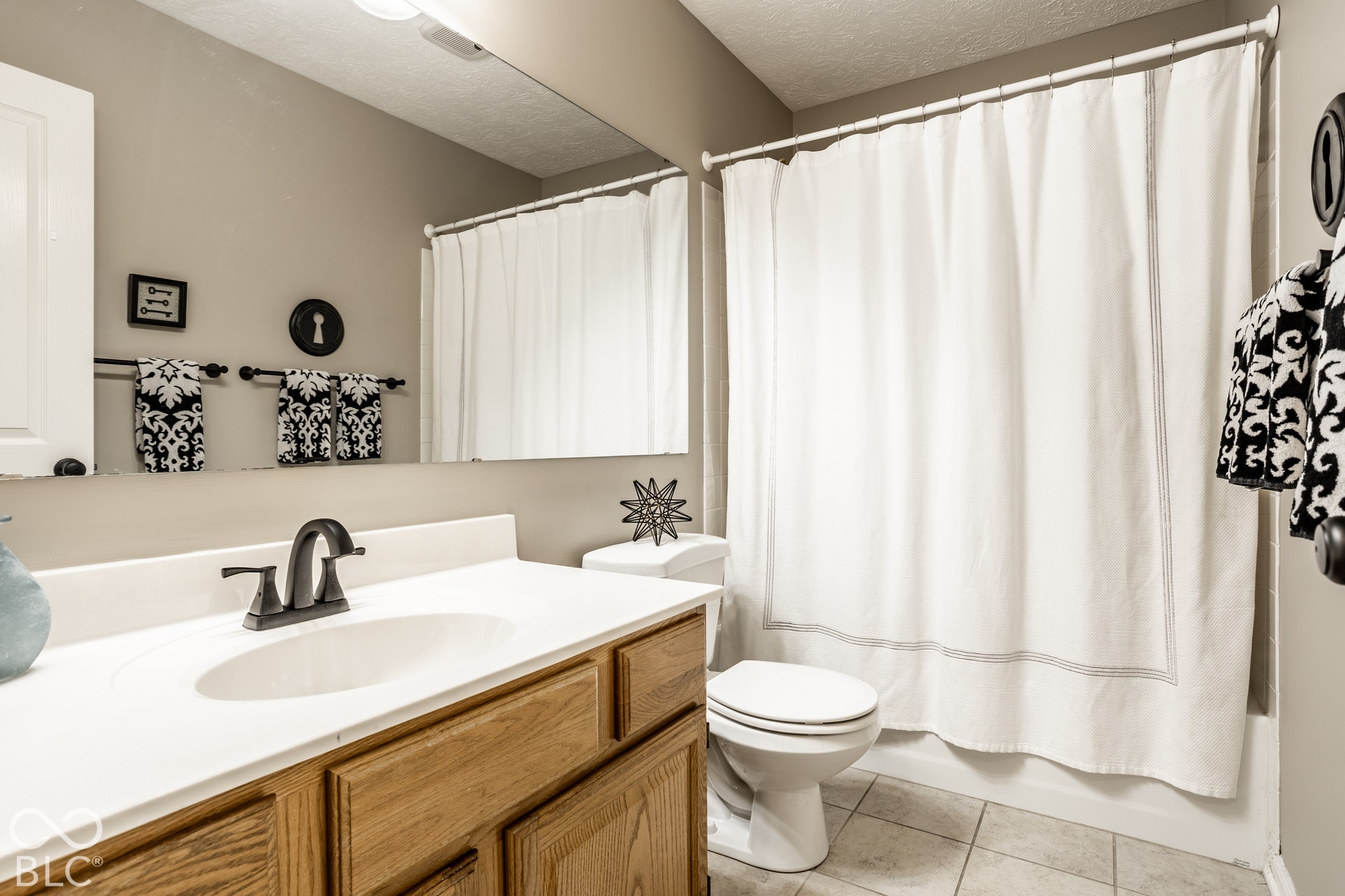 Wood-finish vanity with white countertop and integrated sink
