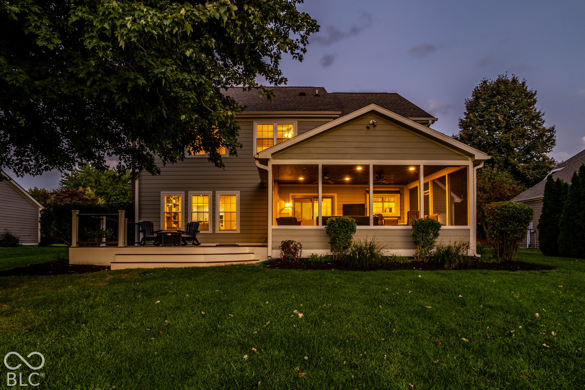 Expansive backyard featuring a screened-in porch with recessed lighting, an exterior deck, and a manicured lawn