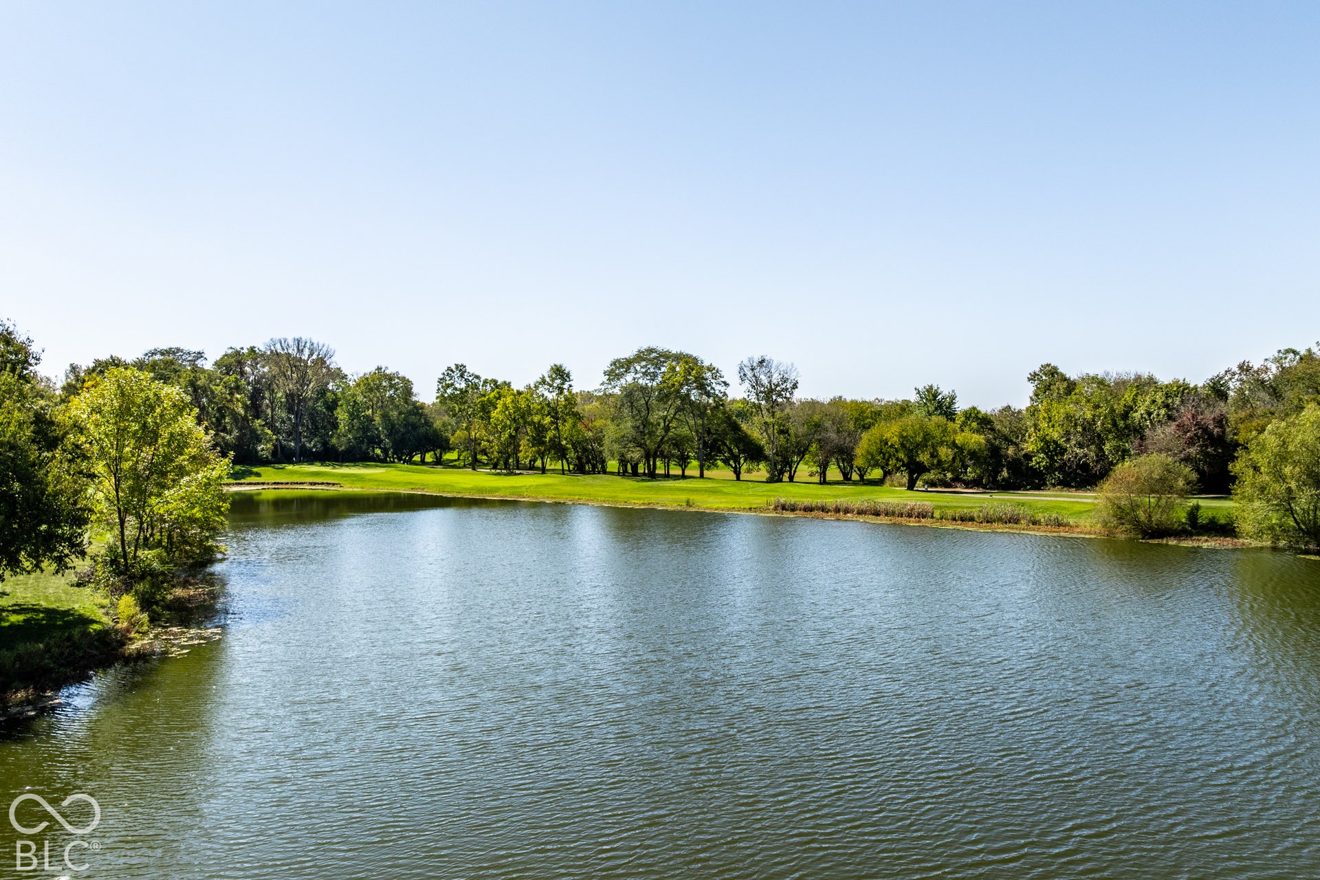 Expansive water view with a lush green landscape and mature trees