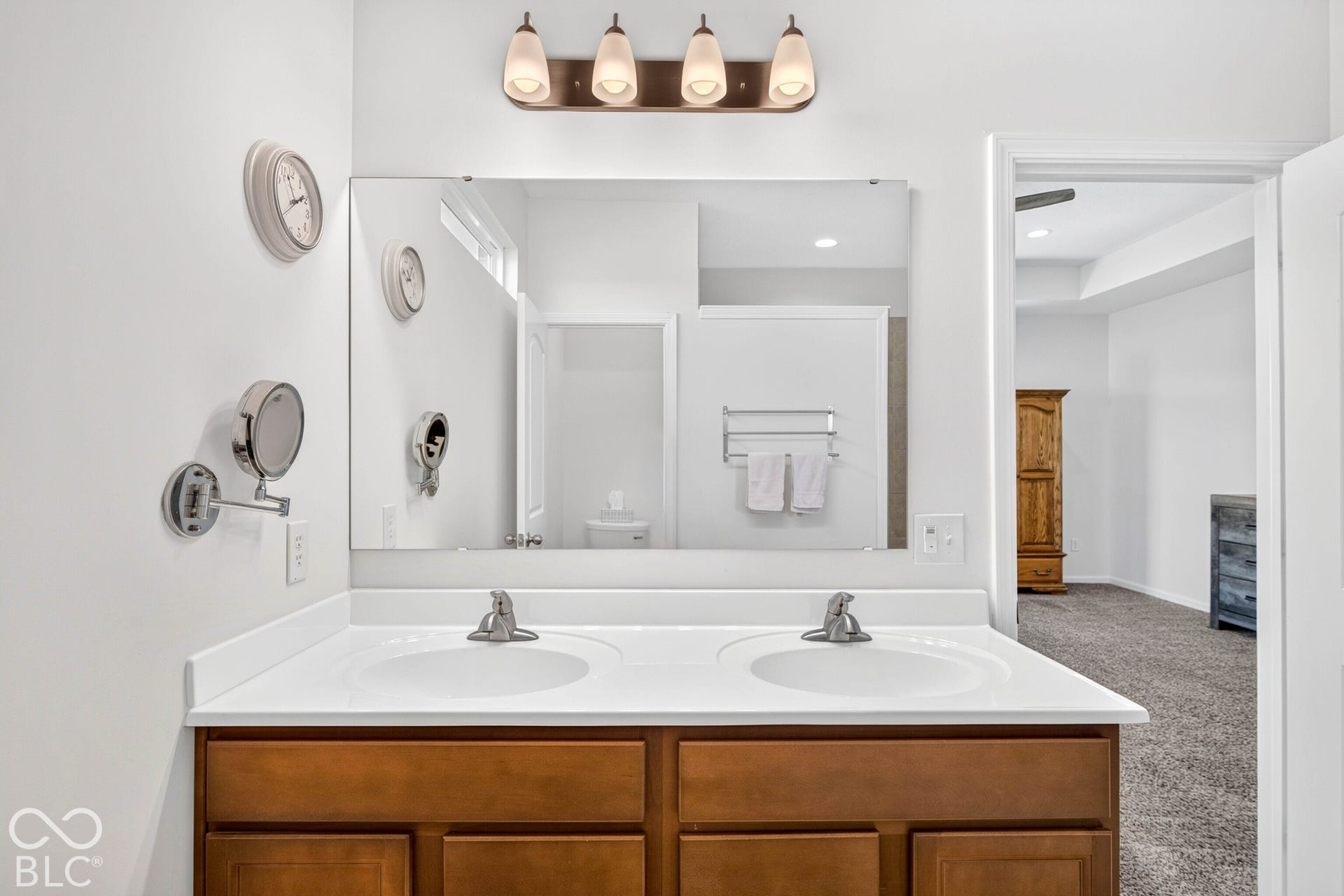 Dual vanity with wood-finish cabinetry and white countertops