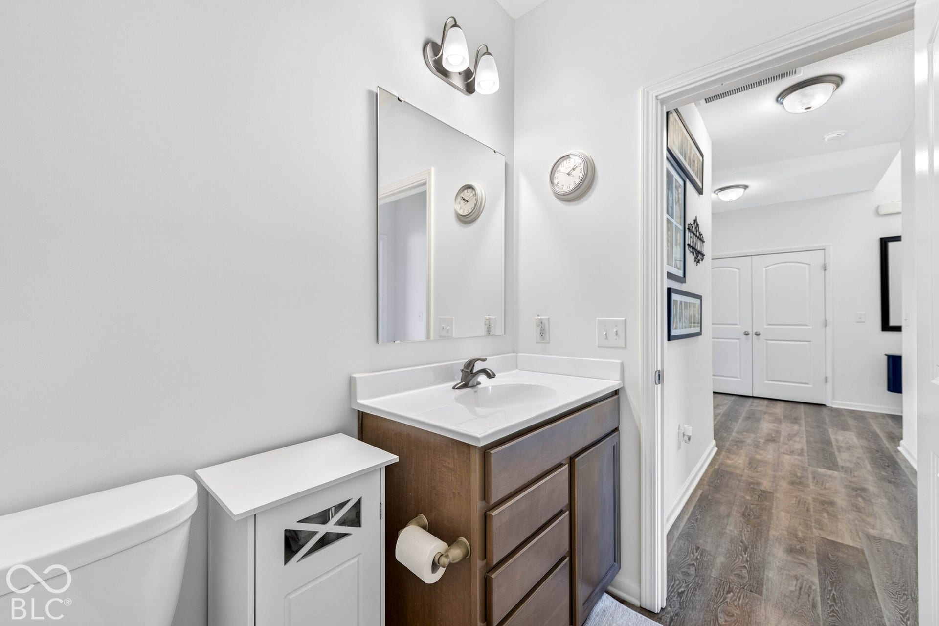 Bathroom featuring a single vanity with wood-finish cabinetry, a white countertop, and a rectangular sink