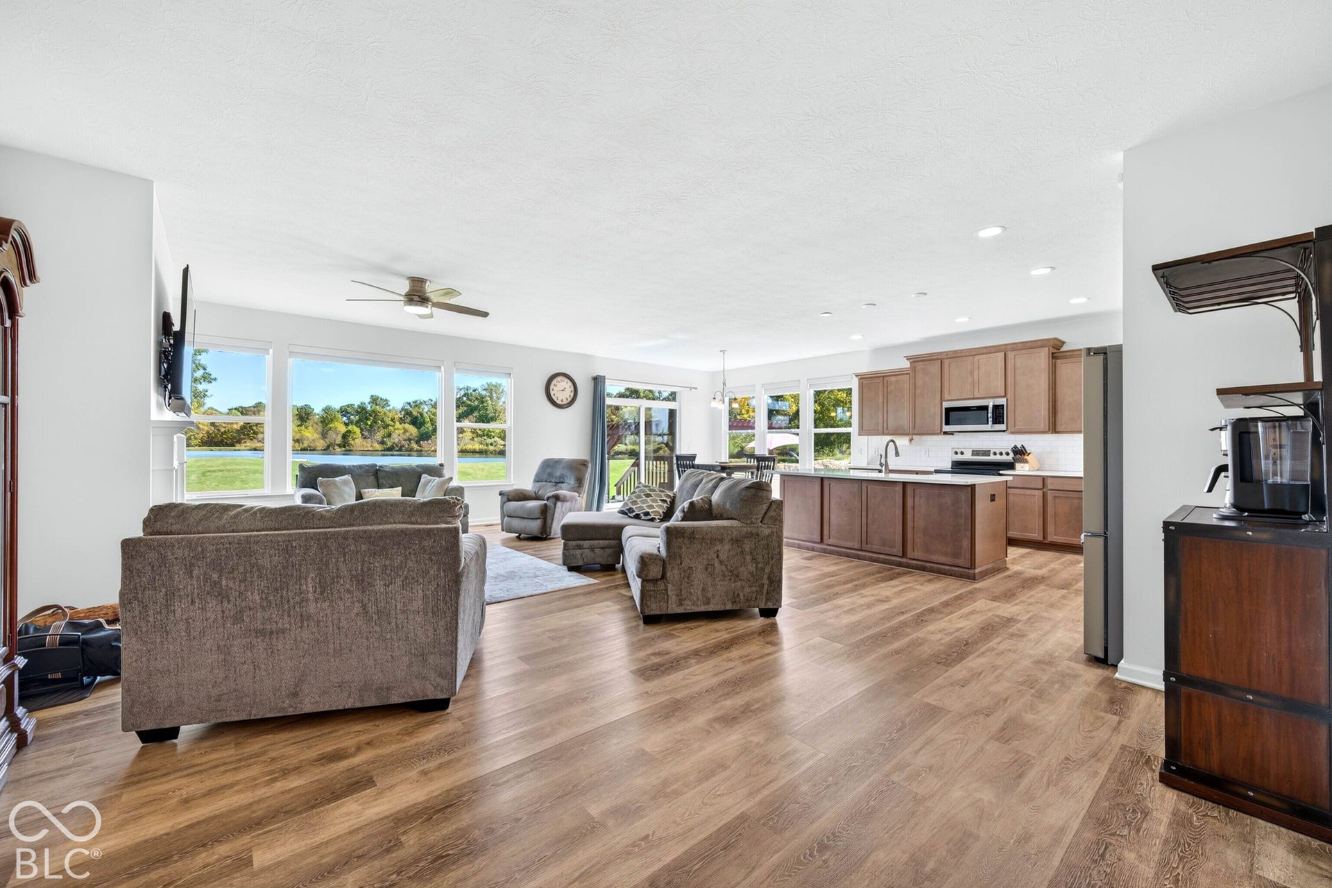 Expansive living area featuring wood-finish flooring, recessed lighting, and a ceiling fan