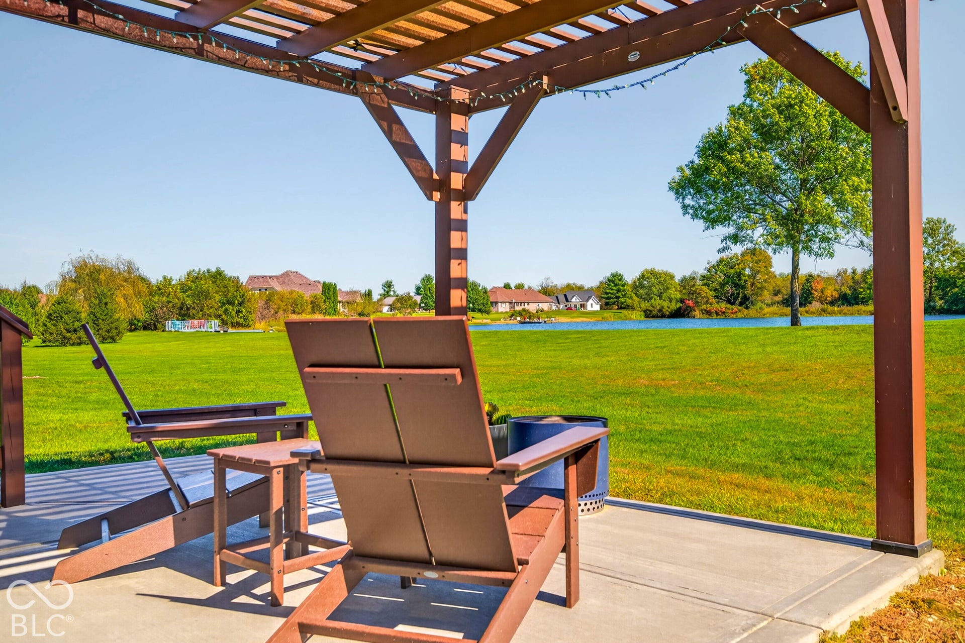 Expansive concrete patio with a wooden pergola structure